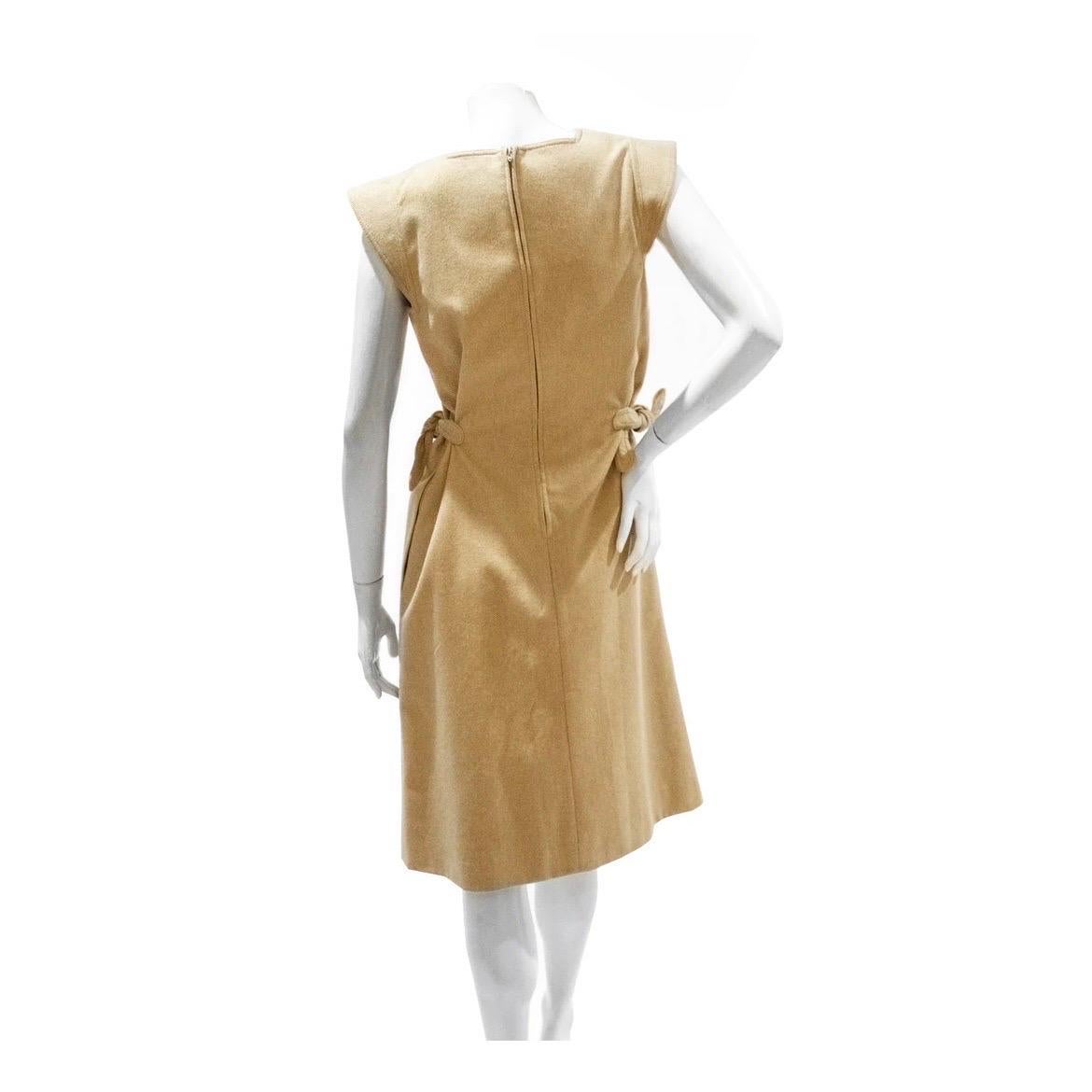 Pierre Cardin Dress 
Circa late 1960's or early 1970's 
Vintage 
Tan Wool 
Square neckline 
Cap sleeve 
Tie knot detail on left and right side of waist 
Knot details are adjustable for fit 
The dress has an elegant pleat detail to its design 
Sheath