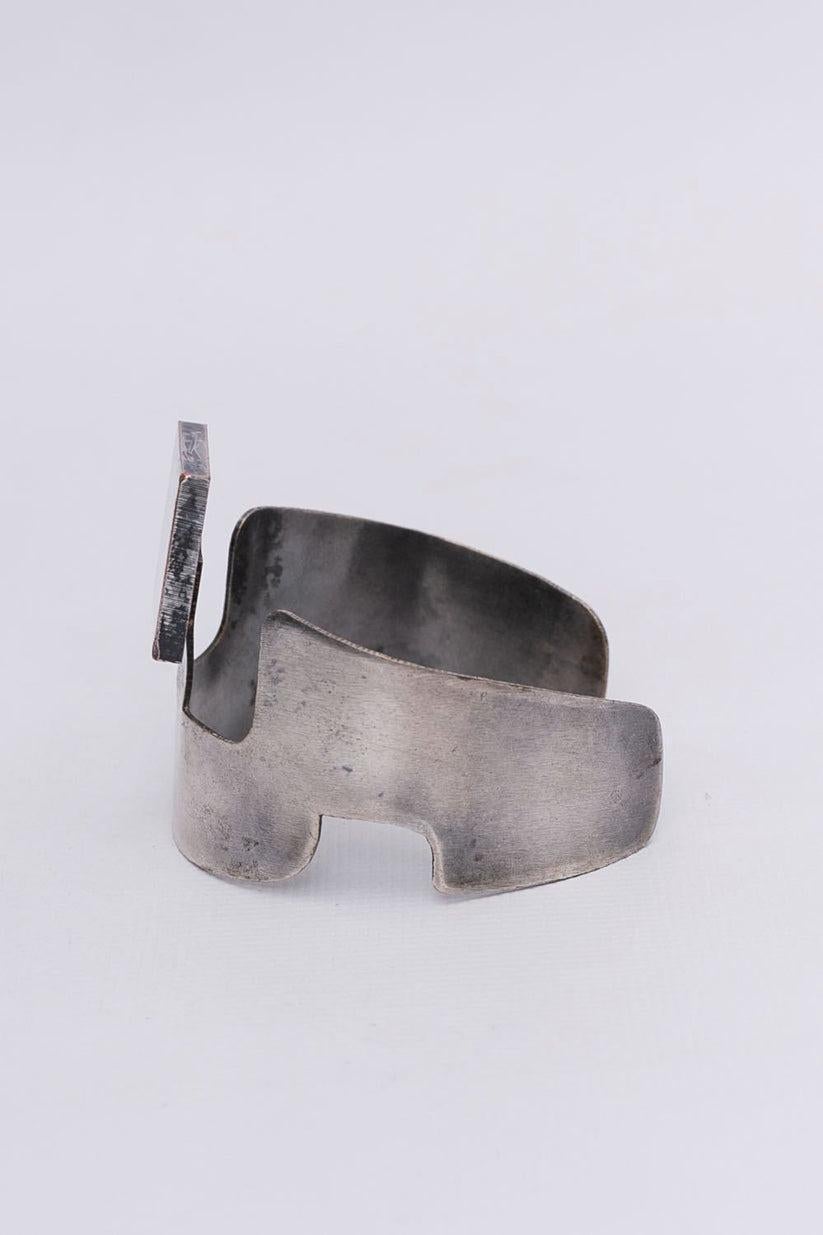 Pierre Cardin - Cuff bracelet in silvery metal in a geometric shape.

Additional information:
Condition: Good general condition. Some silver coating missing
Dimensions: Circumference: 15 cm (5.9