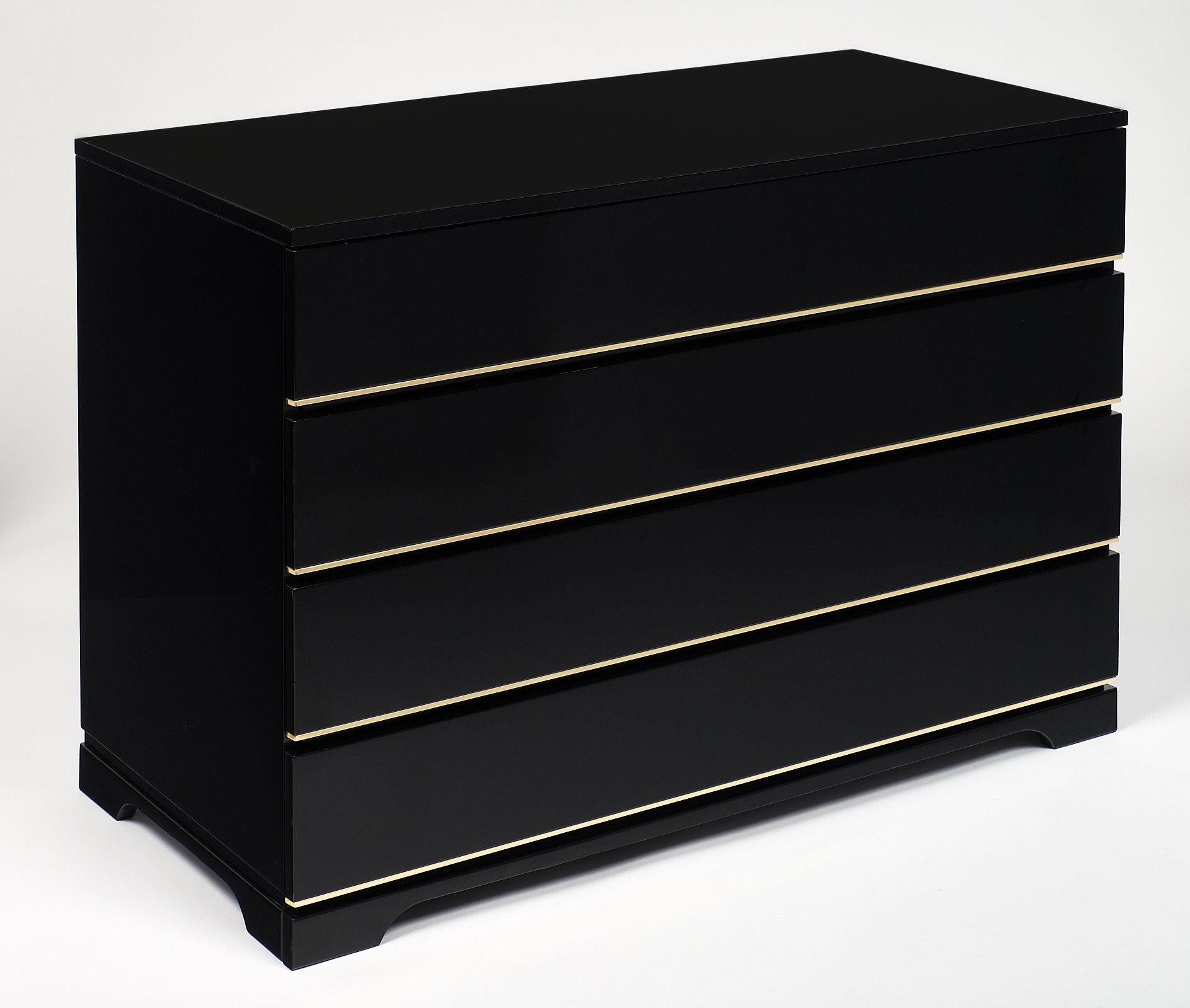 A bold yet elegant modernist French chest of four drawers in fine condition with brass trims. Made of wood and lacquered, this piece is in the style of designer Pierre Cardin. The functional, strong cabinet will keep its low understated profile