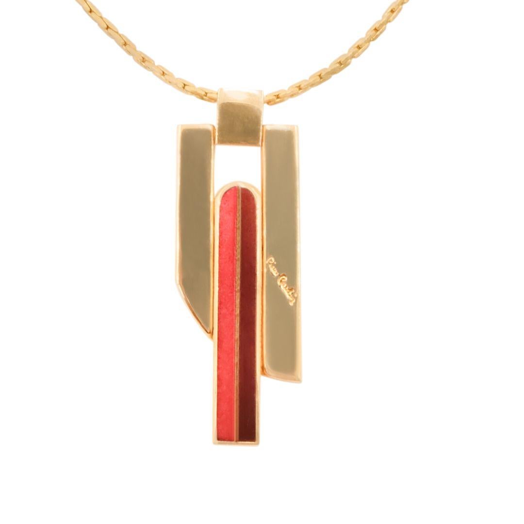 Mid-Century era Art-Deco style gold plated chain necklace with geometric dual tone red striped enamel pendant. 

Pierre Cardin signature engraving on the front.

Condition Details: In excellent, gently used condition consistent with its age and use.
