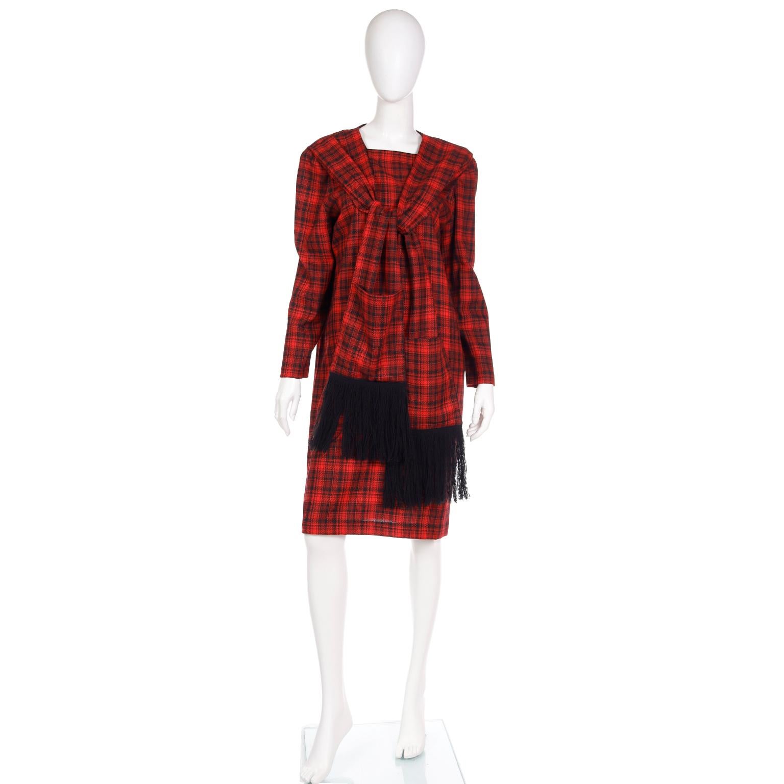 This late 1970's or early 1980's Pierre Cardin red plaid wool long sleeve dress is so unique and very wearable today! The shift silhouette and simple square neck are accentuated with attached panels that mimic a fringed scarf with pockets on each