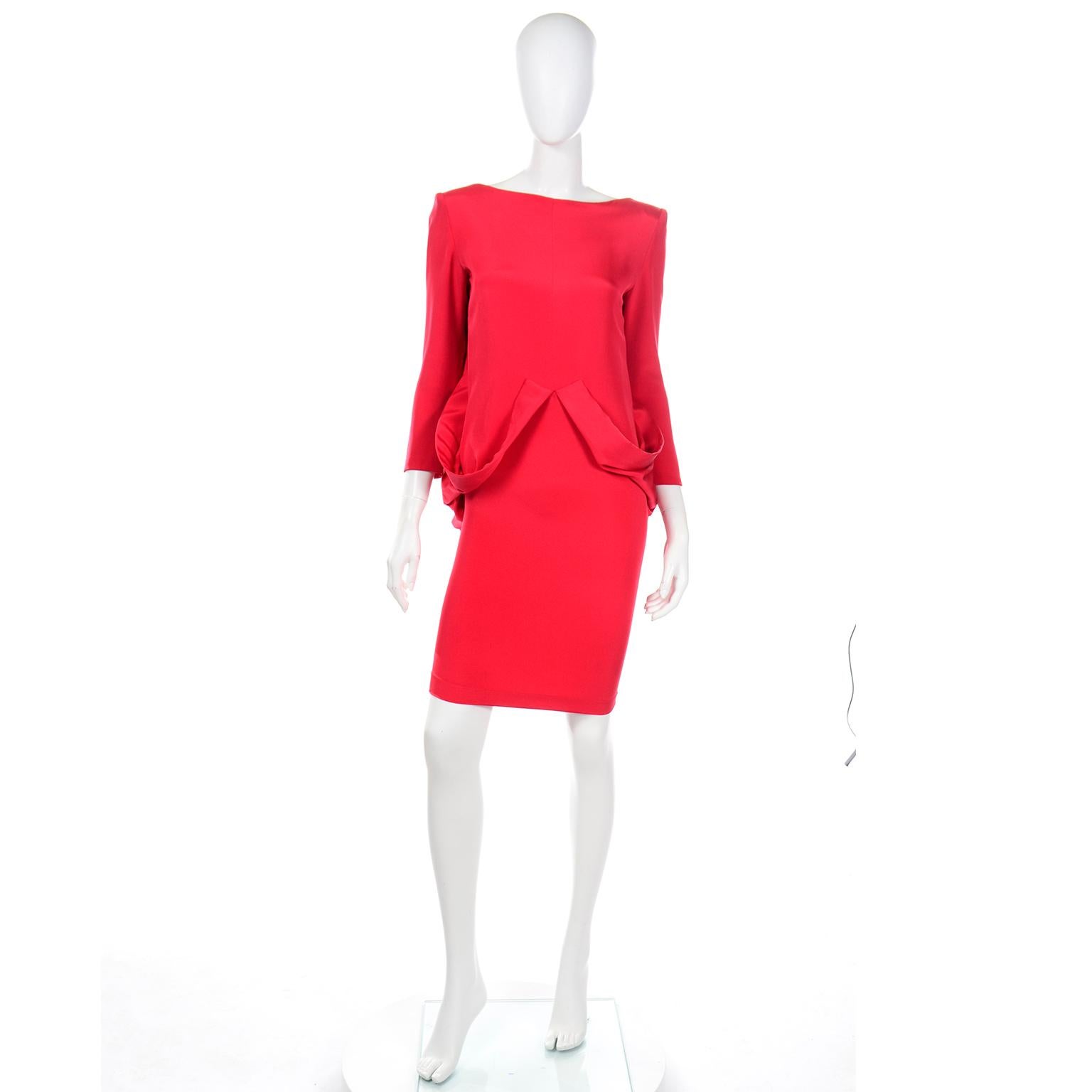 Cette robe unique en crêpe de soie rouge vintage Pierre Cardin capture l'esprit avant-gardiste des créations Pierre Cardin. Le devant est une simple robe droite, avec deux boucles de tissu attachées qui se drapent de la taille et le long des hanches