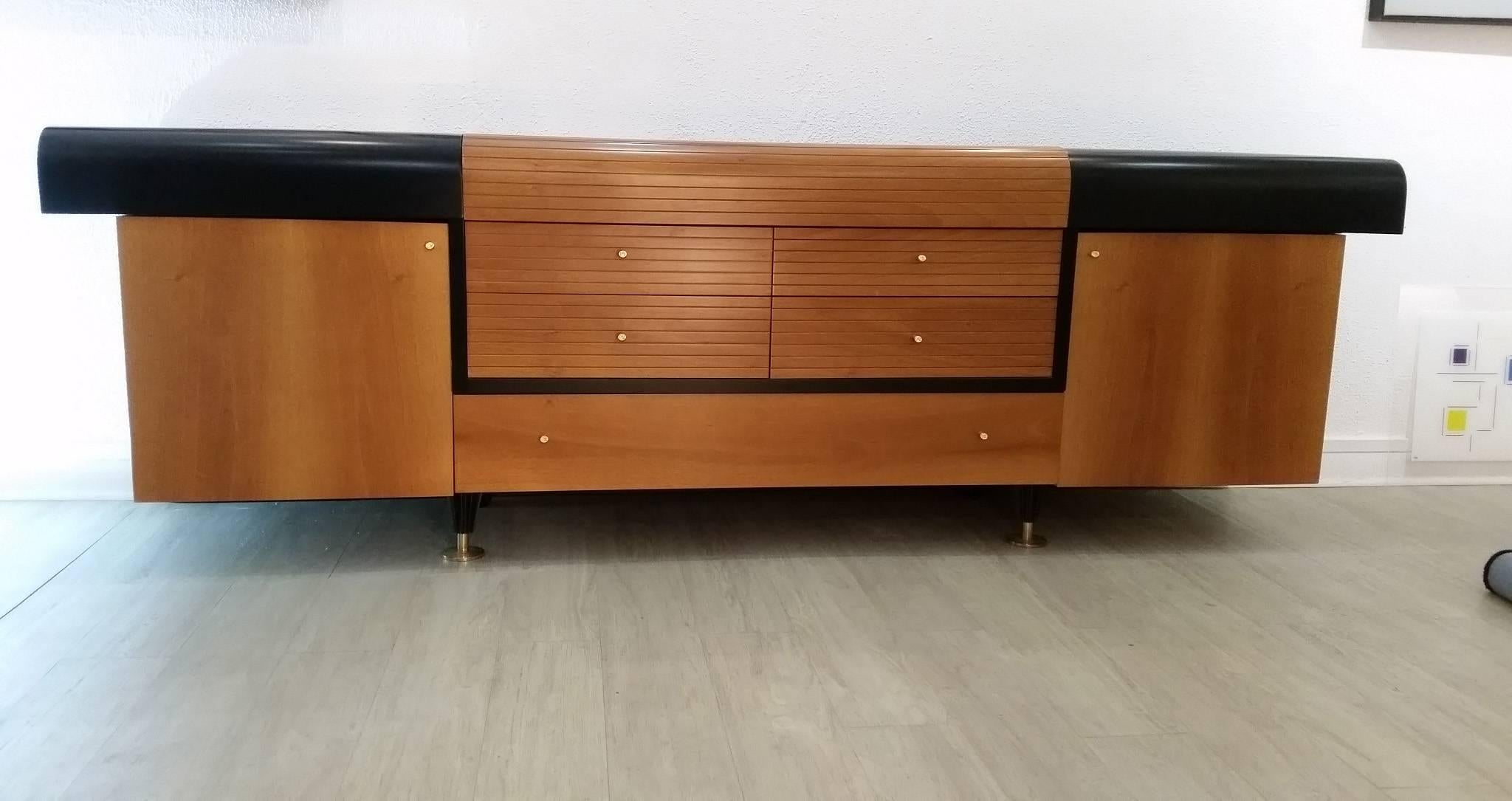 Rare graphic Buffet of the French designer Pierre Cardin
Vintage,
circa 1980
Black lacquered wood and teak
Handles signed / engraved by the designer with his logo
This sideboard has five drawers in the middle, two top flaps on each side forming
