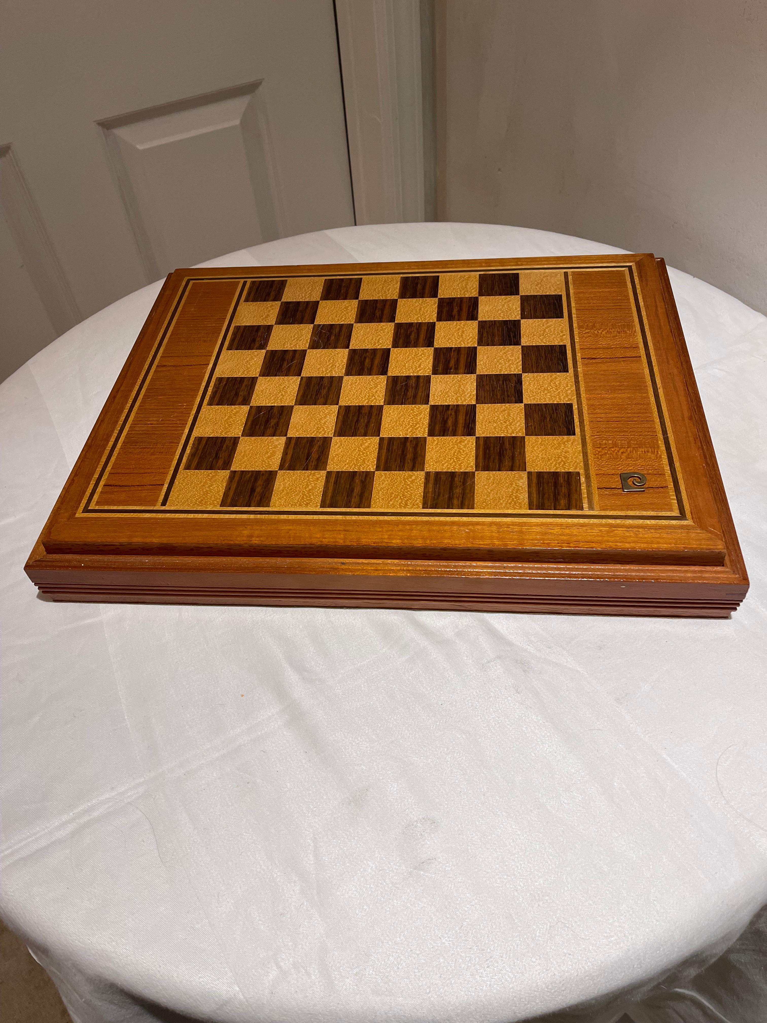 Pierre Cardin Wood Chess Set and Backgammon Set with 32 pieces stored in the case.  Made in the 1970s but brand new with original tags, logo and pamphlet. Chess pieces are hand carved and made of wood. The backgammon pieces and dice are plastic with