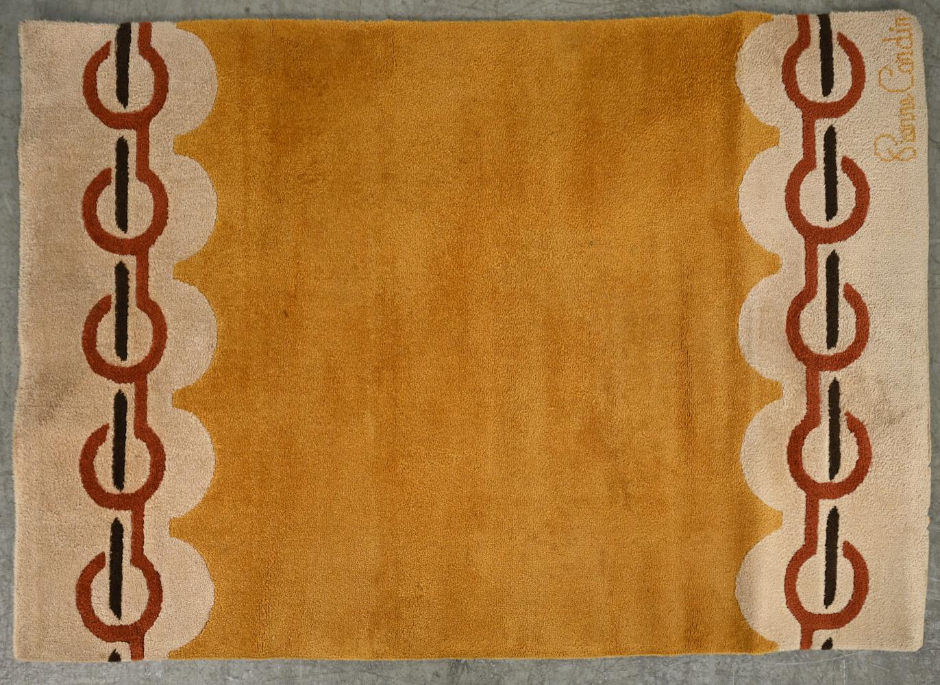 A stylish wool pile area rug by Pierre Cardin in orange and beige.