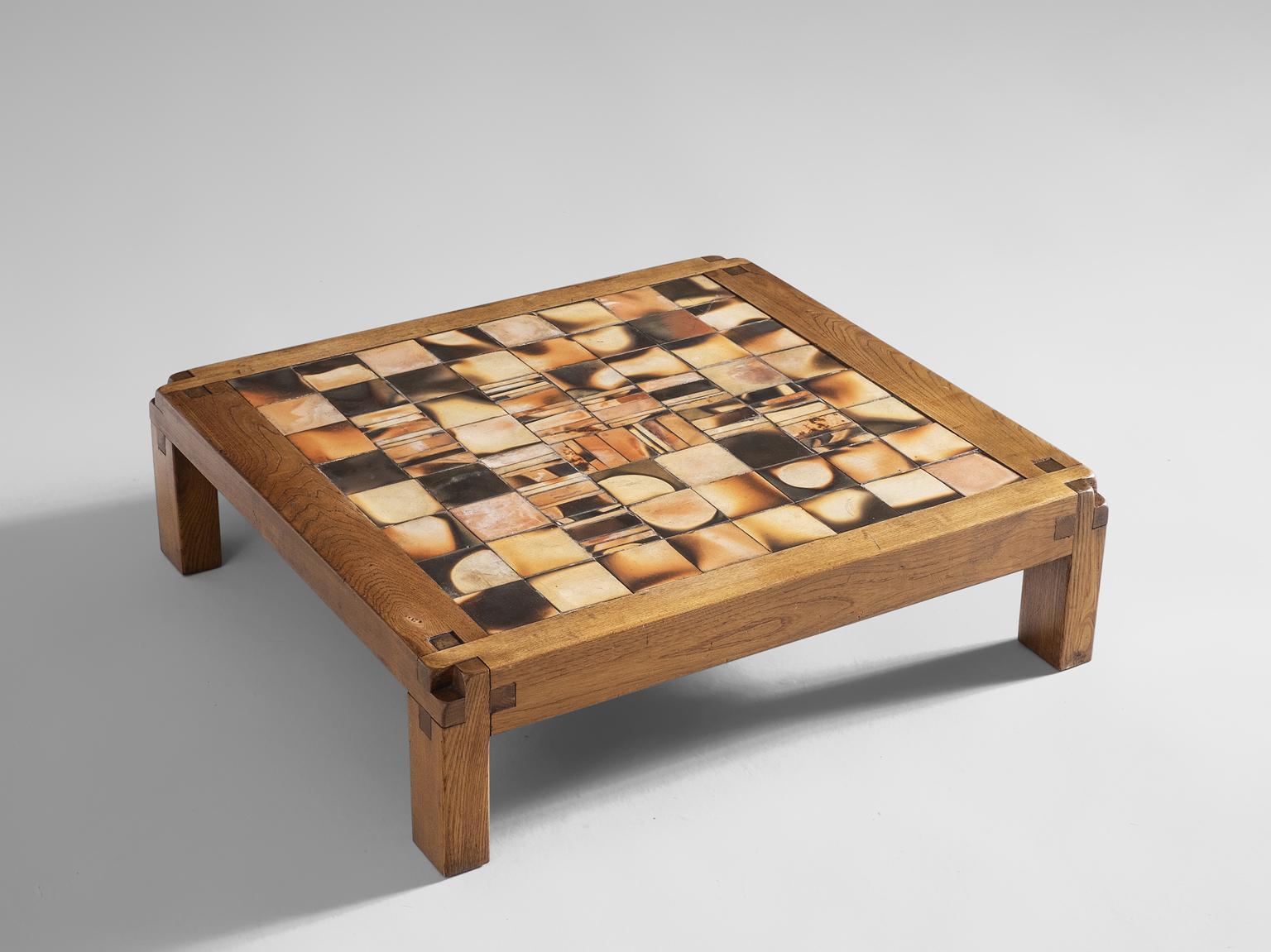 Pierre Chapo, coffee table, elmwood and glazed stoneware, France, 1960s. 

Nearly square coffee table. The wooden construction show absolutely stunning wood joints, a trademark of Chapo. The top is tessellated with 64 glazed tiles, in shades of
