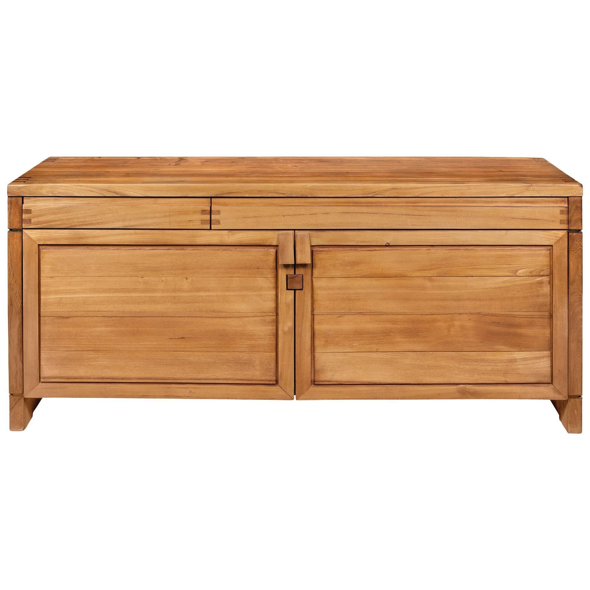 Pierre Chapo (1927–1987)

Superbly crafted, sparely designed, and imposingly scaled two-door sideboard by master artisan Pierre Chapo. In solid elm with brass hinges, asymmetrical frieze drawers, and beautiful exposed joinery, emblematic of Chapo’s