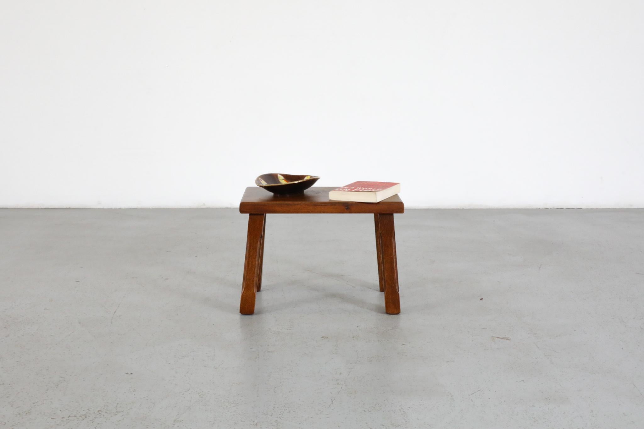 Brutalist dark oak side table inspired by Pierre Chapo with beautiful warm brown color and carved detail on the legs. Lightly refinished with some visible wear and scratching. Perfect little side table, plant stand or small stool. (Not recommended