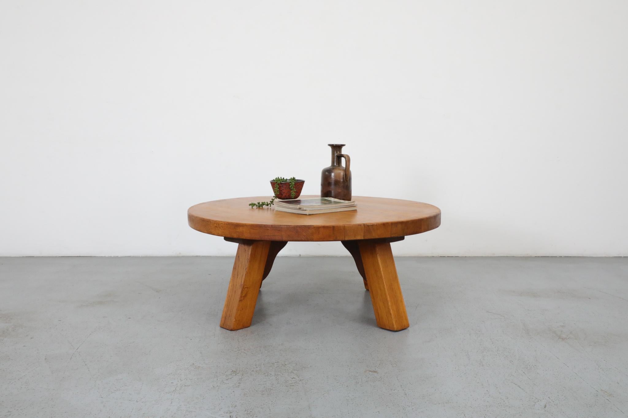 Dutch Mid-Century, Brutalist style, low and round oak coffee table. Inspired by the work of influential French post-war design great Pierre Chapo. This is a handsomely and robustly designed oak piece, outfitted with angled legs with carved