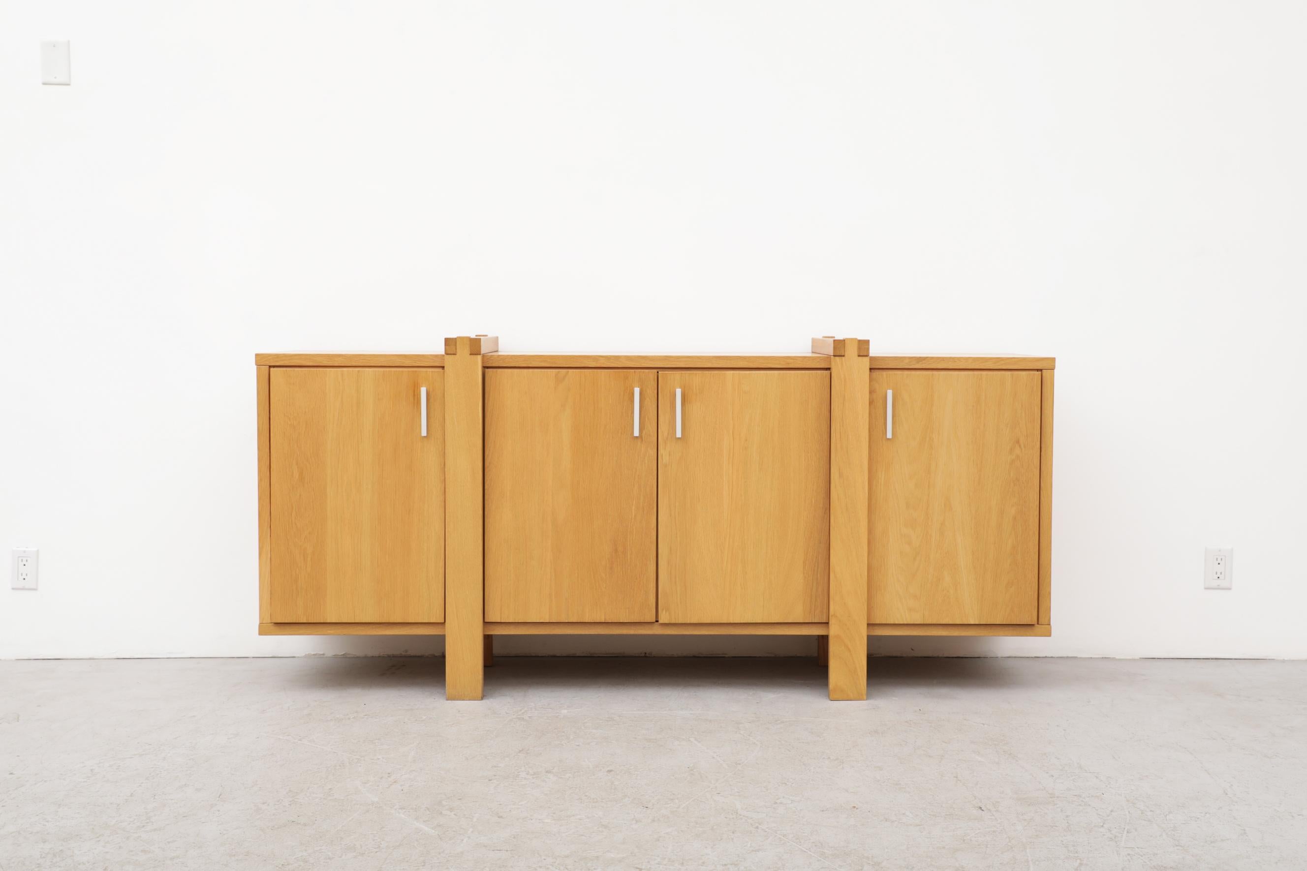 Pierre Chapo inspired oak sideboard with aluminum pulls, 4 storage cabinets and box joint detail. Handsome construction with legs that wrap around the piece. In original condition with visible wear including some wear marks and chipping. Wear is