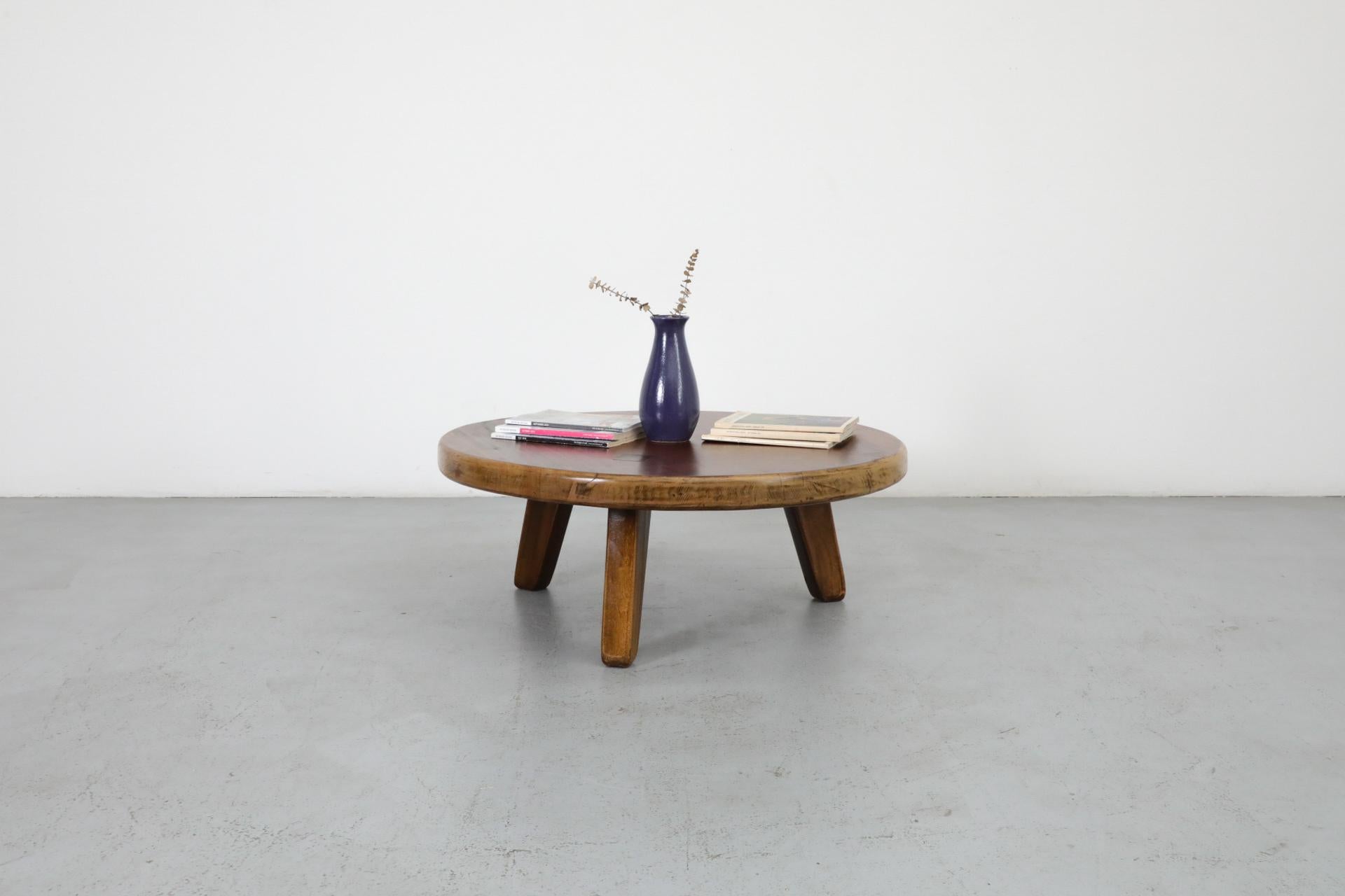 Pierre Chapo inspired, Brutalist solid multi-toned oak coffee table with three triangular shaped legs. Each leg is joined to the table top with a thick mortise and tenon. The tenons are exposed on the surface of the table, and darker in tone. In