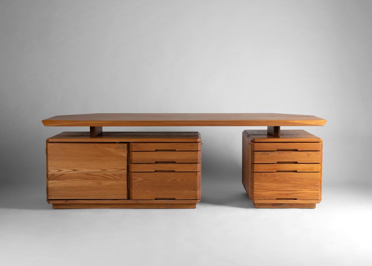 This extraordinary desk carved from elm, has a broad top that rests upon two modular filing cabinets.