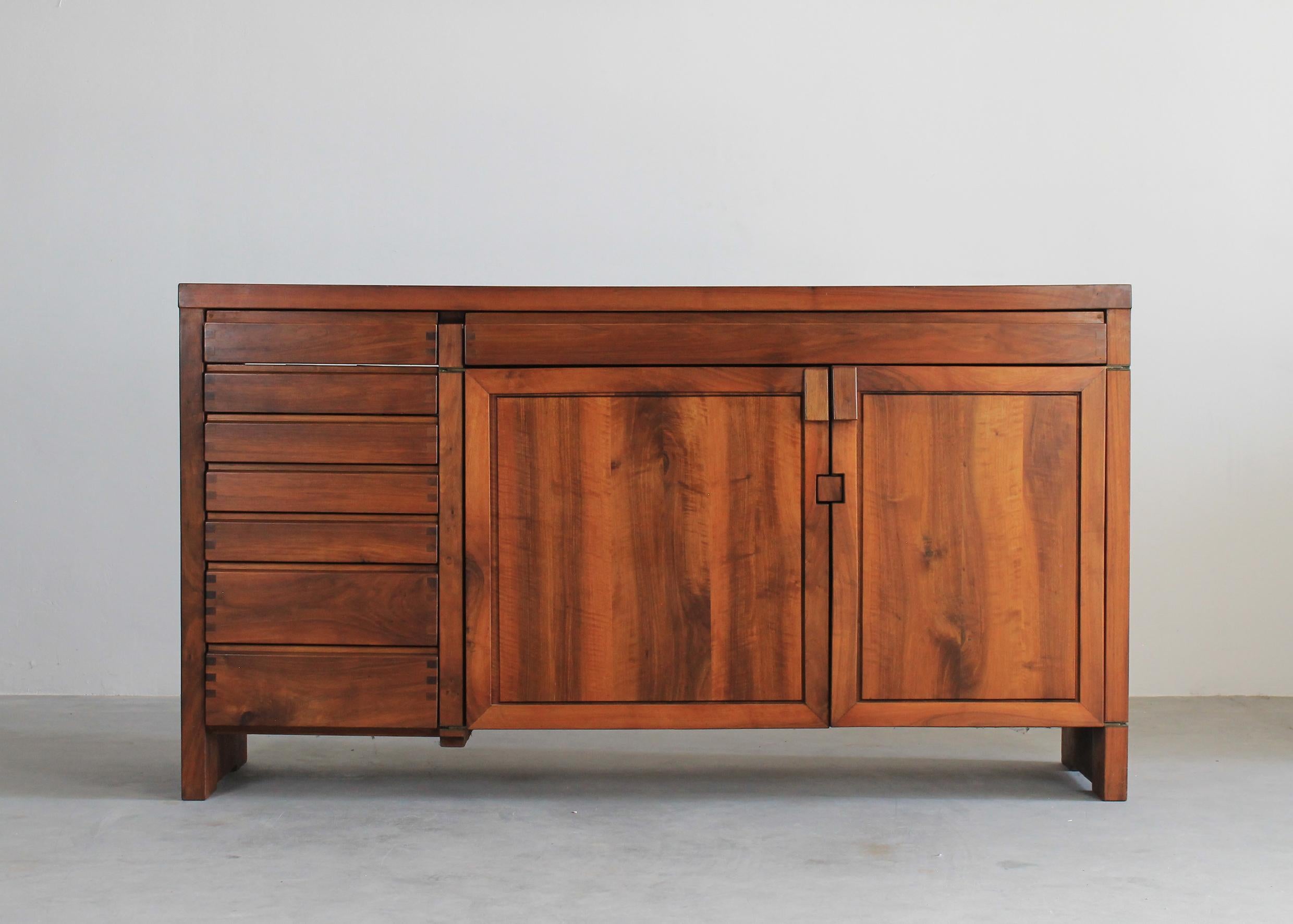 High R13 sideboard or buffet entirely realized in elmwood, the sideboard presents eight drawers (seven on a side and one large frontal drawer) and two doors revealing on the inside some shelves. 
The R13 sideboard was designed by the French