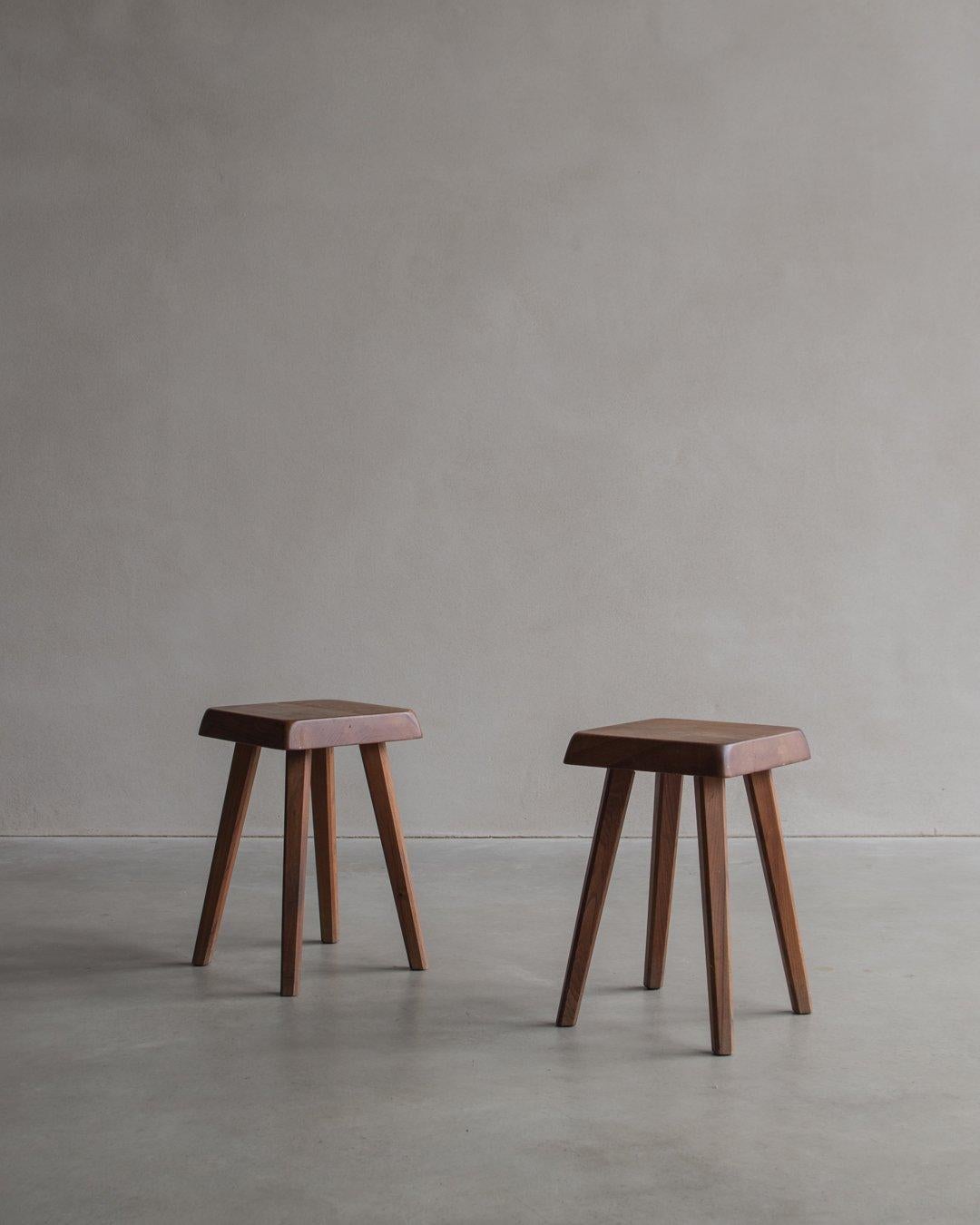 Le tabouret S01, conçu par le célèbre architecte français Pierre Chapo dans les années 1960, se caractérise par une assise carrée aux bords arrondis et inclinés, soutenue par quatre pieds. L'artisanat met en évidence la qualité du travail du bois et