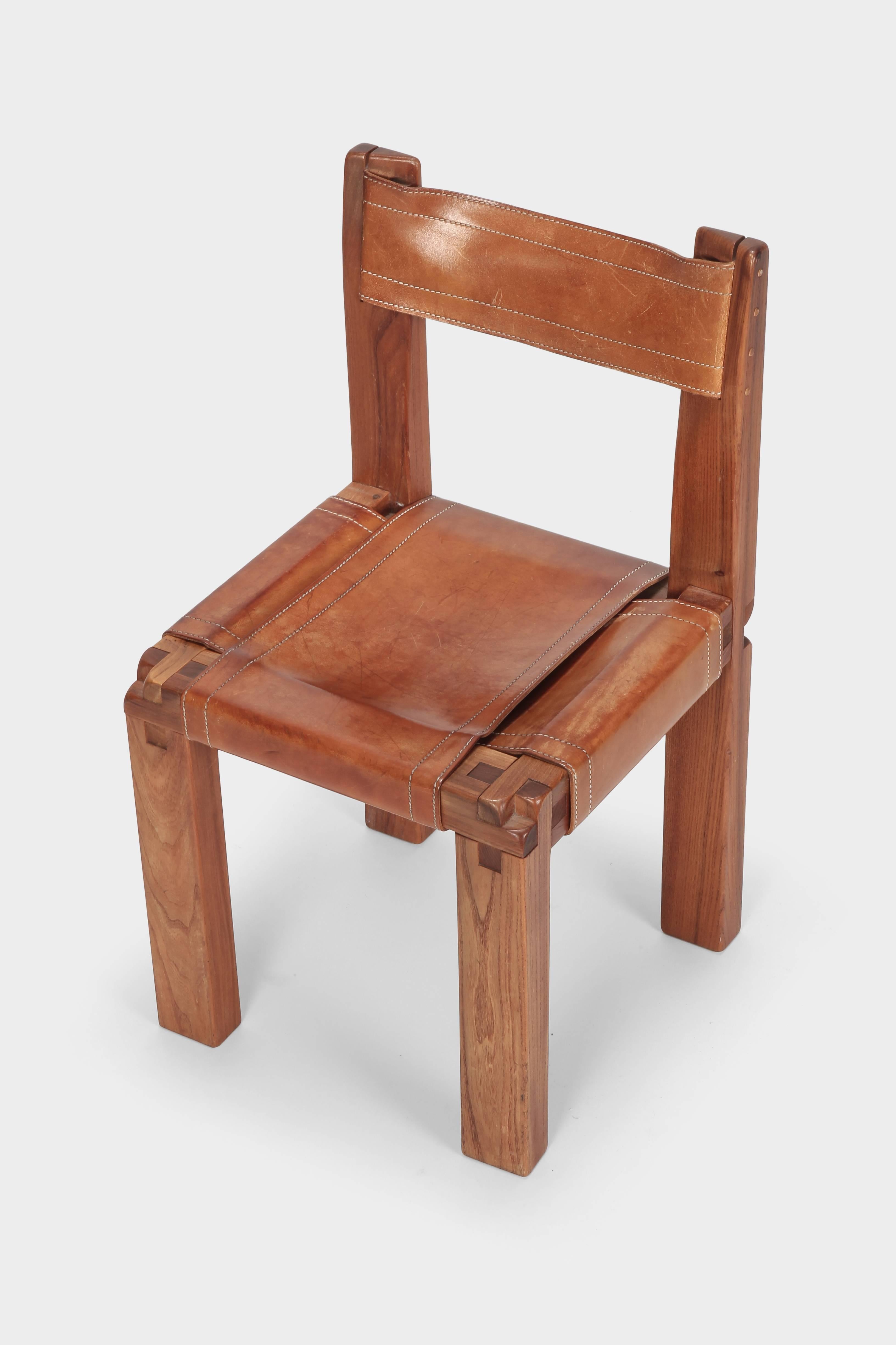 Pierre Chapo chair S11 manufactured in France in the 1960s. Solid elmwood frame, cognac brown saddle leather seating and back. This chair has a cubic design and shows absolutely stunning wood joints. The thick saddle leather is beautifully patinated