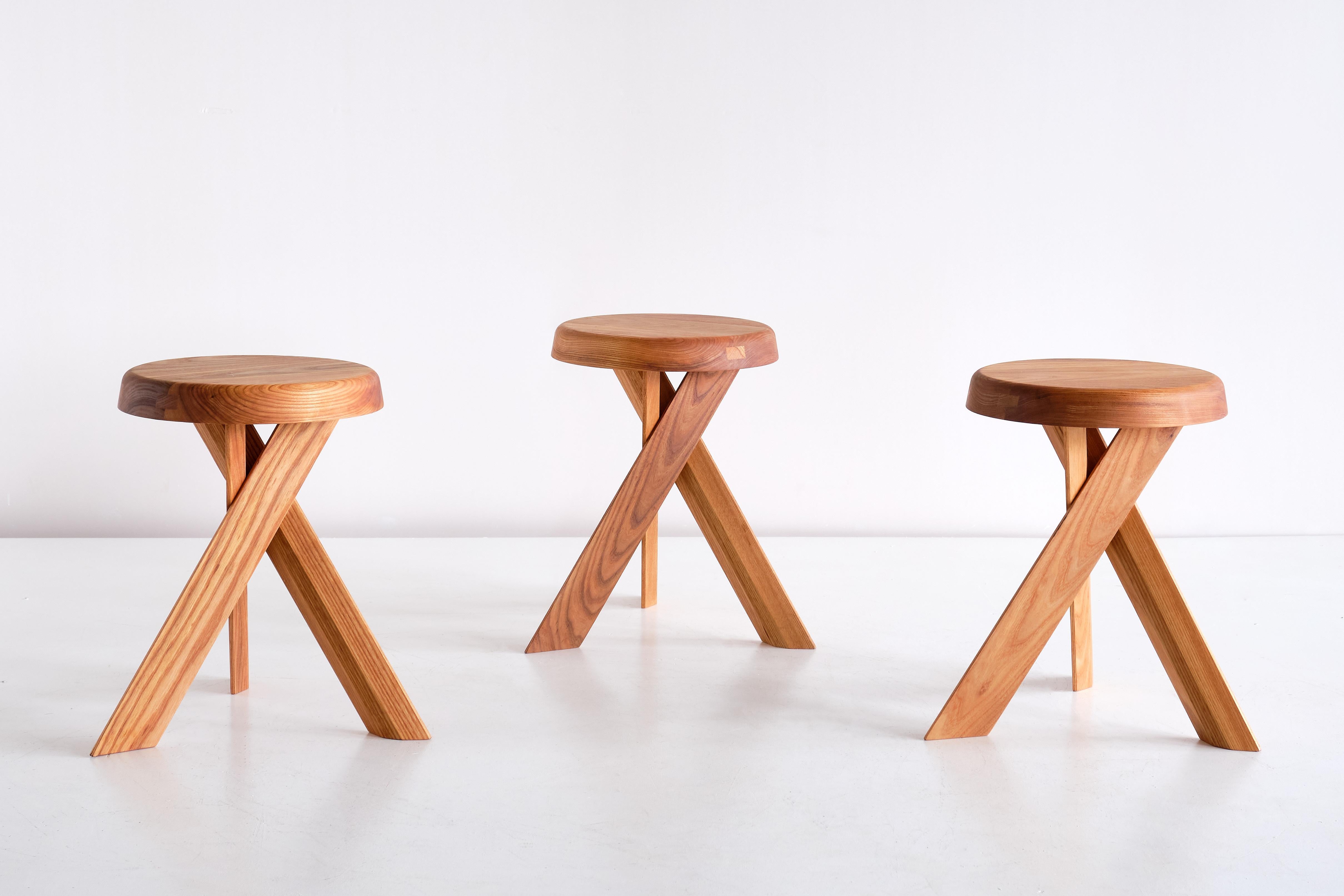 This striking three-legged stool is the model S31A designed by Pierre Chapo in 1974. The cross legged base and round seat are in solid elm wood. This stool also could function as a small side table.

We have one piece in stock available for