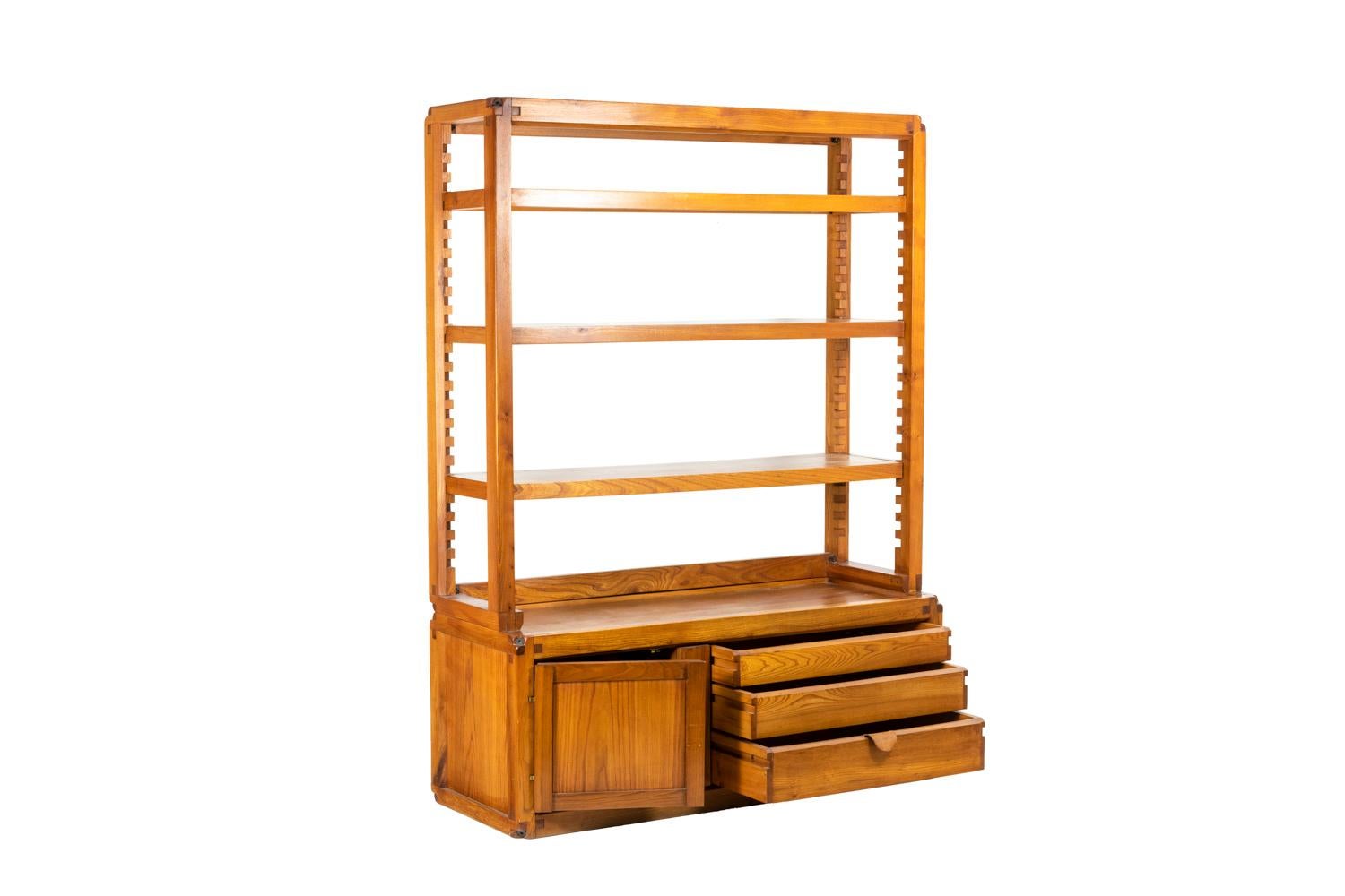 Pierre Chapo, signed.

Shelves cabinet in natural elm composed, in the lower part, by a storage buffet opening with three drawers and presenting a compartment topped by a shelf composed of four tablets.

Model B10.

Source: Hugues Magen