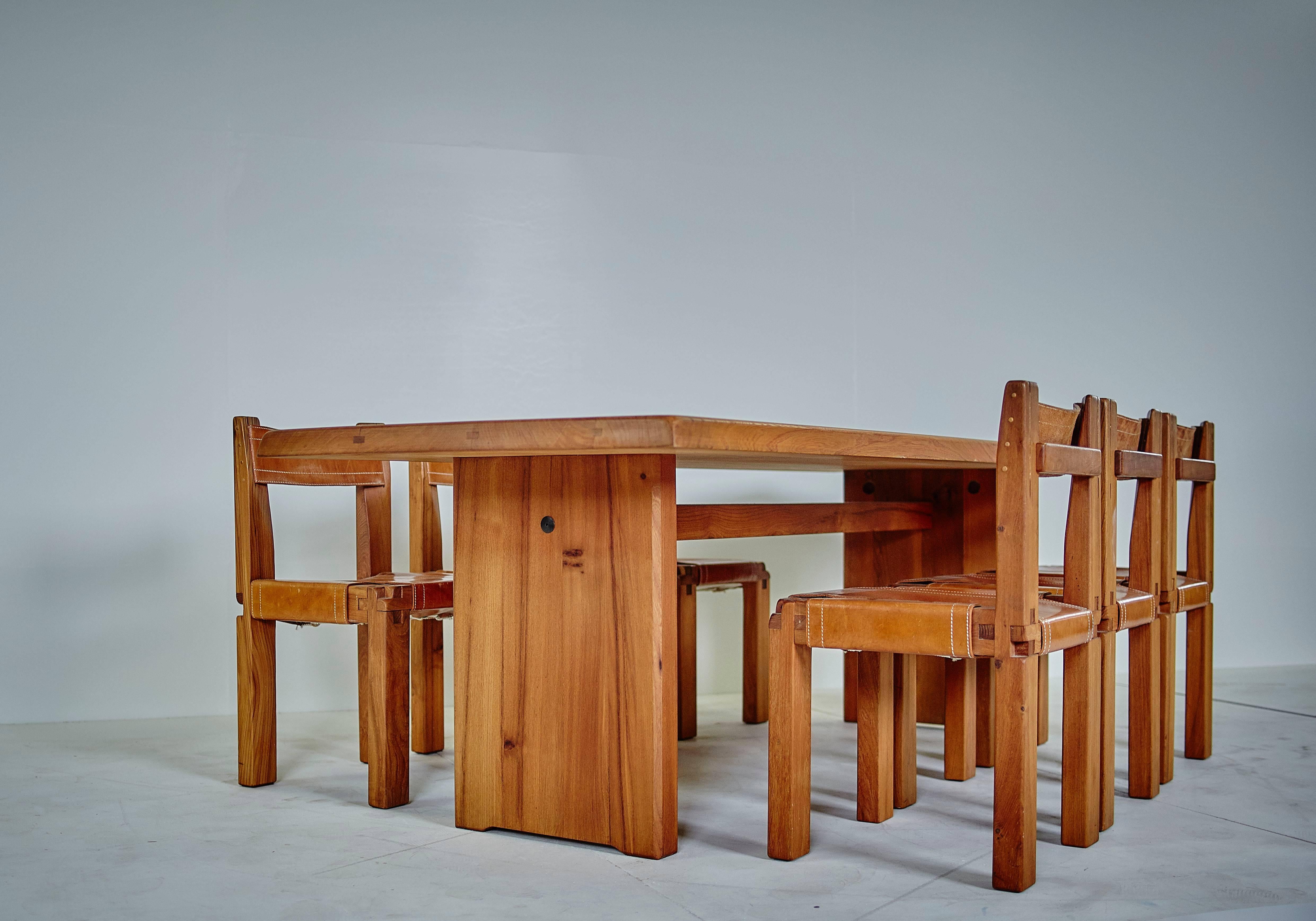 Set comprising a table mod. T14D solid rectangular tray supported by two solid legs joined by a high spacer and six chairs mod. S11, structures in solid elm and leather with cognac patina both for table and the chairs with apparent white saddle