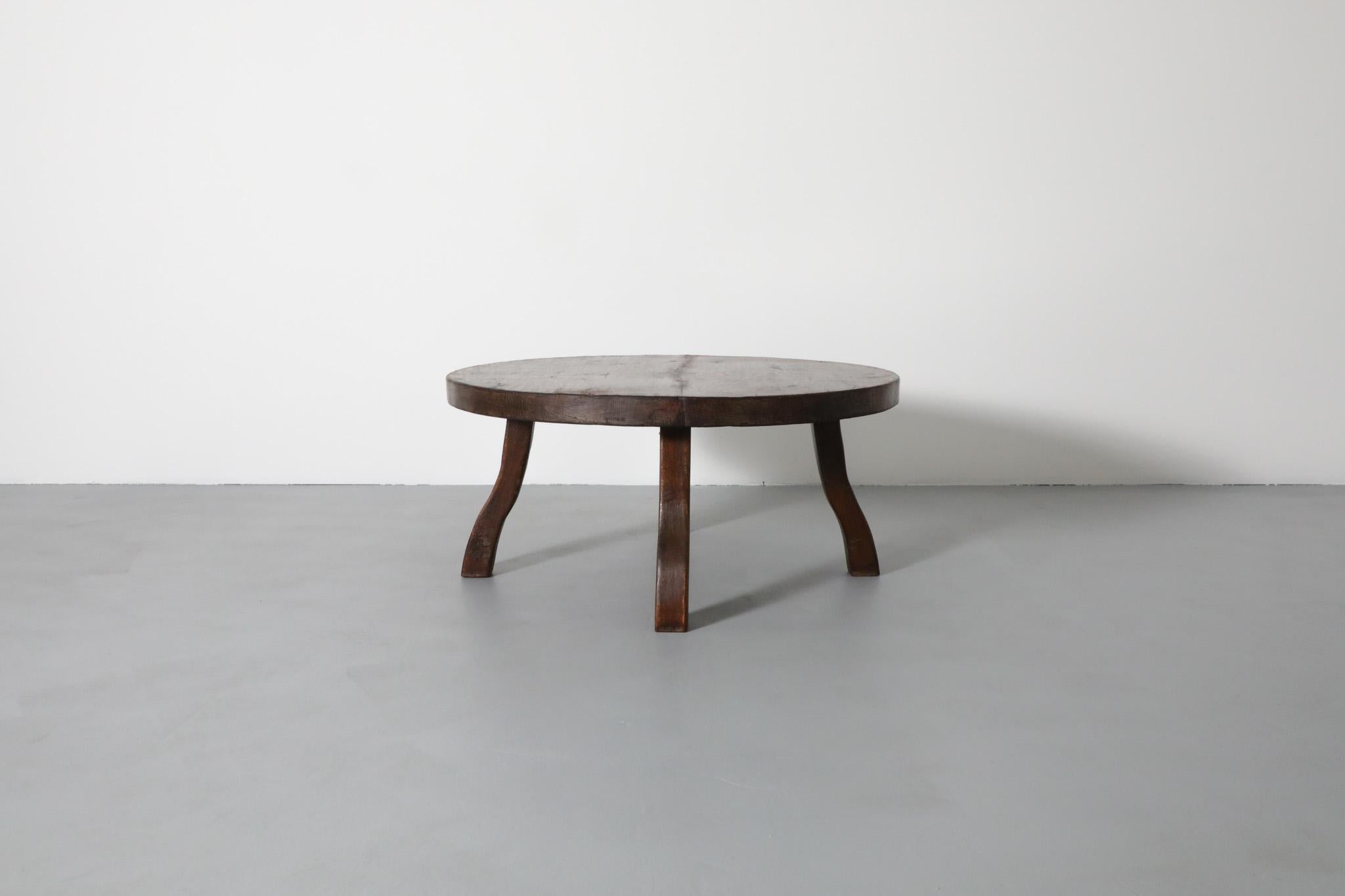 Mid-Century Brutalist coffee table, made of solid oak with four curved legs.  Echoes the work of French Designer Pierre Chapo, The wood is attractively rustic and has some visible wear and patina, including splitting. There was a large split on the