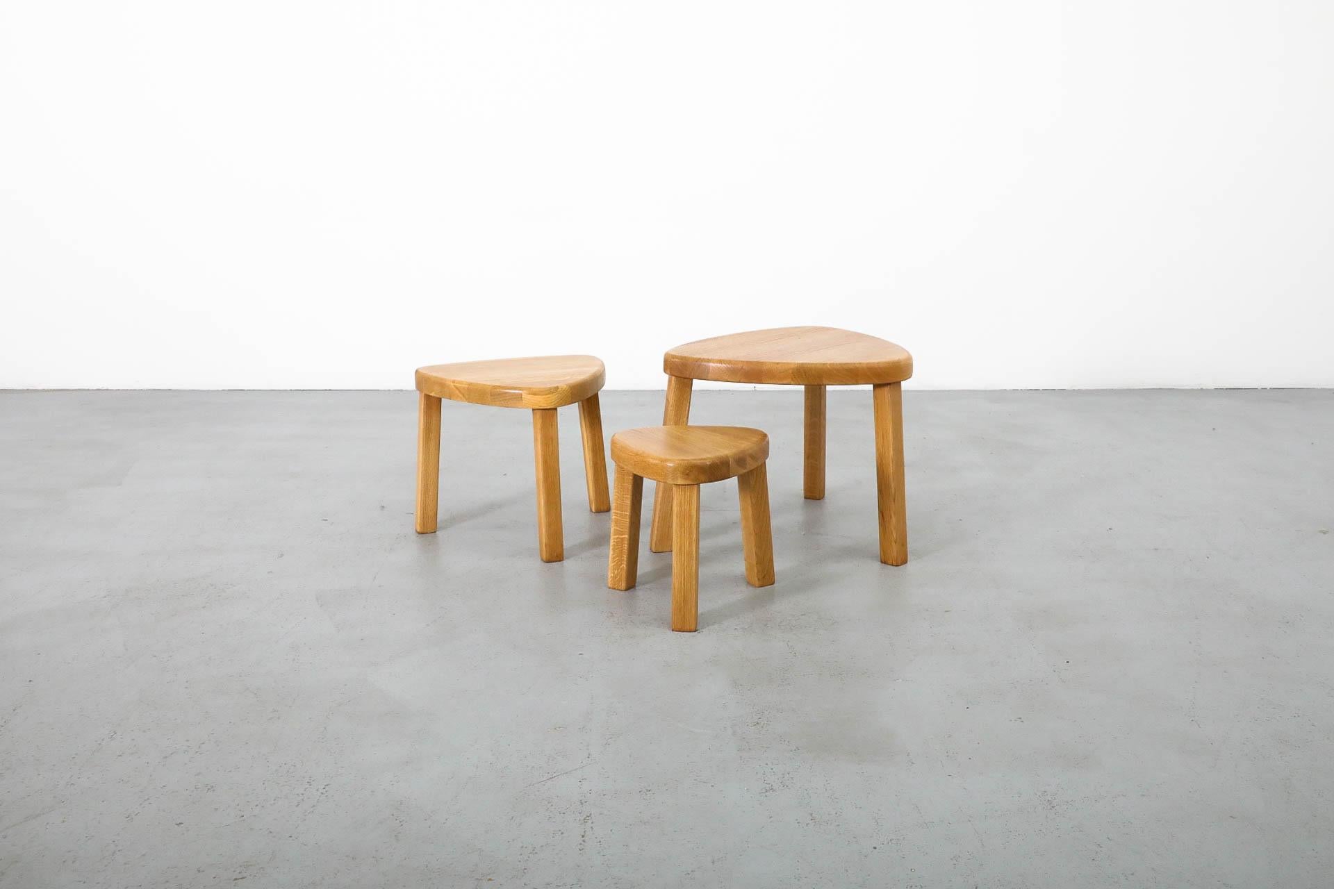 Dutch Mid-Century set of three triangular blonde nesting tables inspired by the work of highly influential French designer Pierre Chapo. Beautiful and solid oak nesting tables with sturdy tripod legs. The set is in good original condition, with