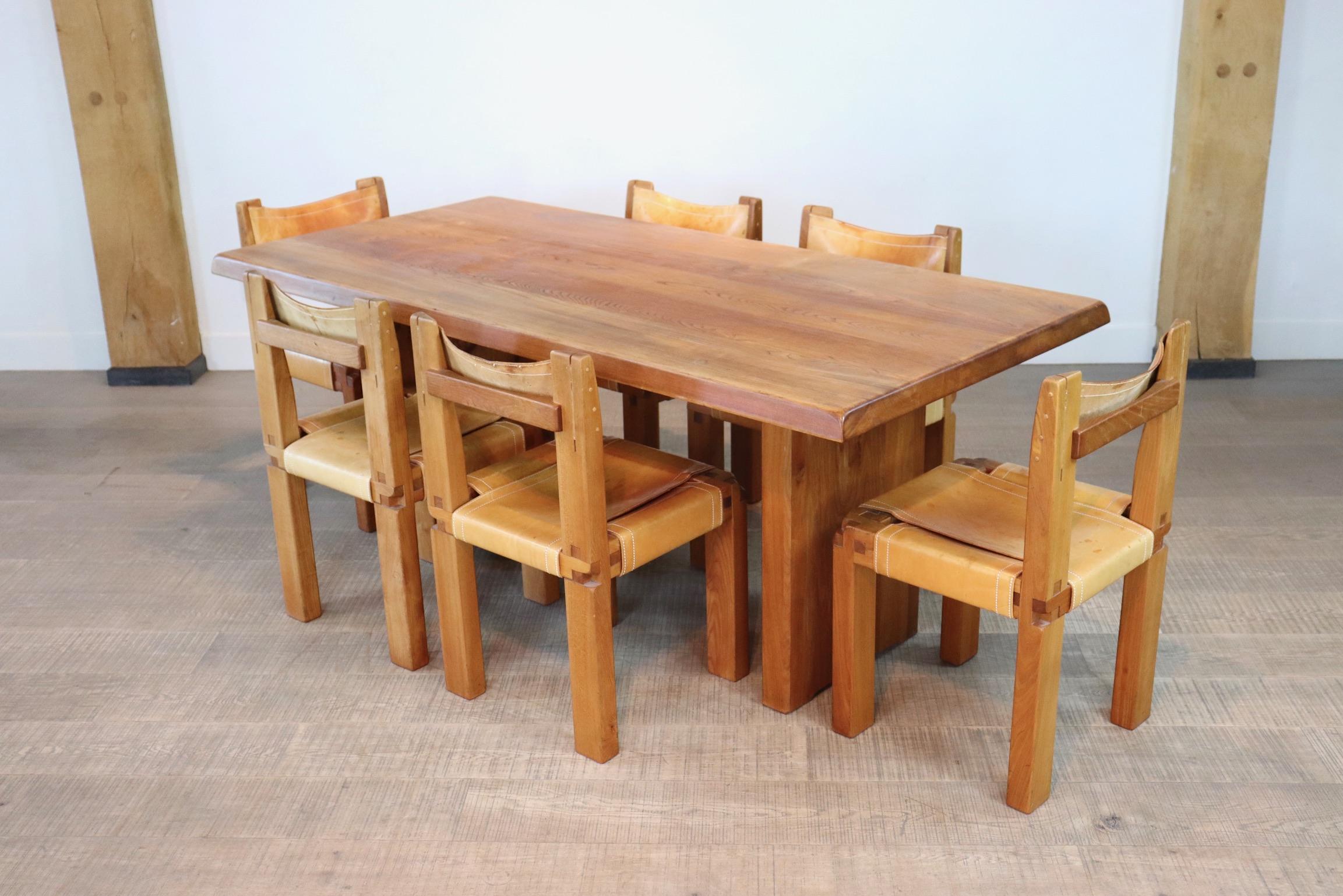 A beautiful dining room set by the French designer Pierre Chapo. The dining table has a strong and minimalistic design which clearly emerges the woods grain and natural look. The rectangular tabletop with sloping edges, rests on a two-legged base.