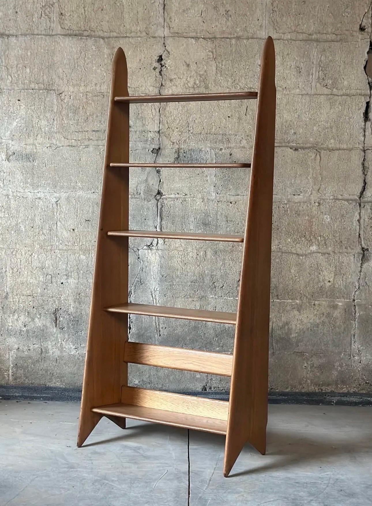 Élégante bibliothèque ou étagère atomique française en chêne blond. Conçu par Pierre Cruège, vers 1955 avec une construction simple, des lignes épurées et des courbes douces qui capturent toutes les facettes du minimalisme moderne du milieu du
