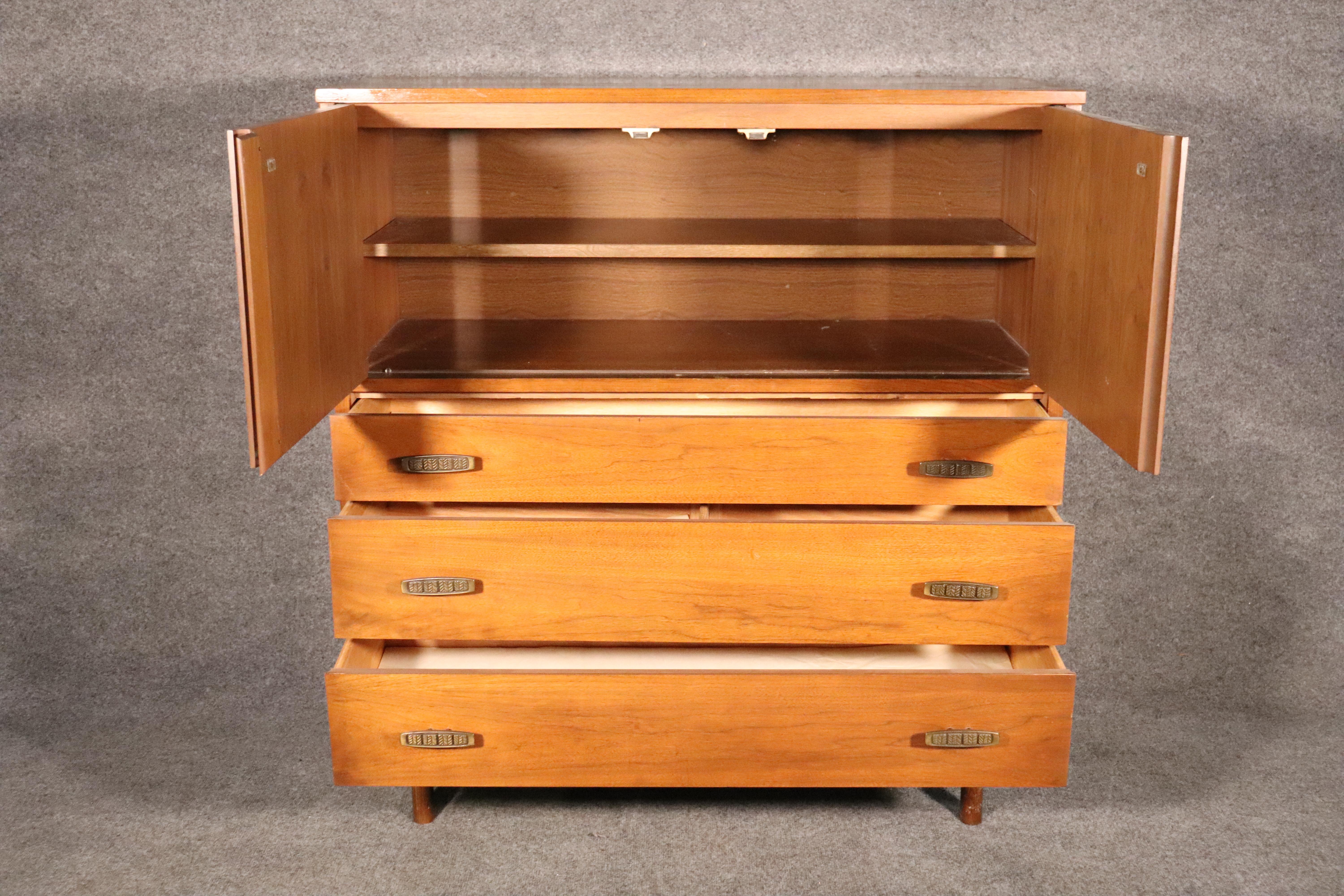 Tall chest of drawers designed by Pierre Debs for Bassett furniture. Rich walnut with brass hardware. Three wide drawers and top chest.
Please confirm location.