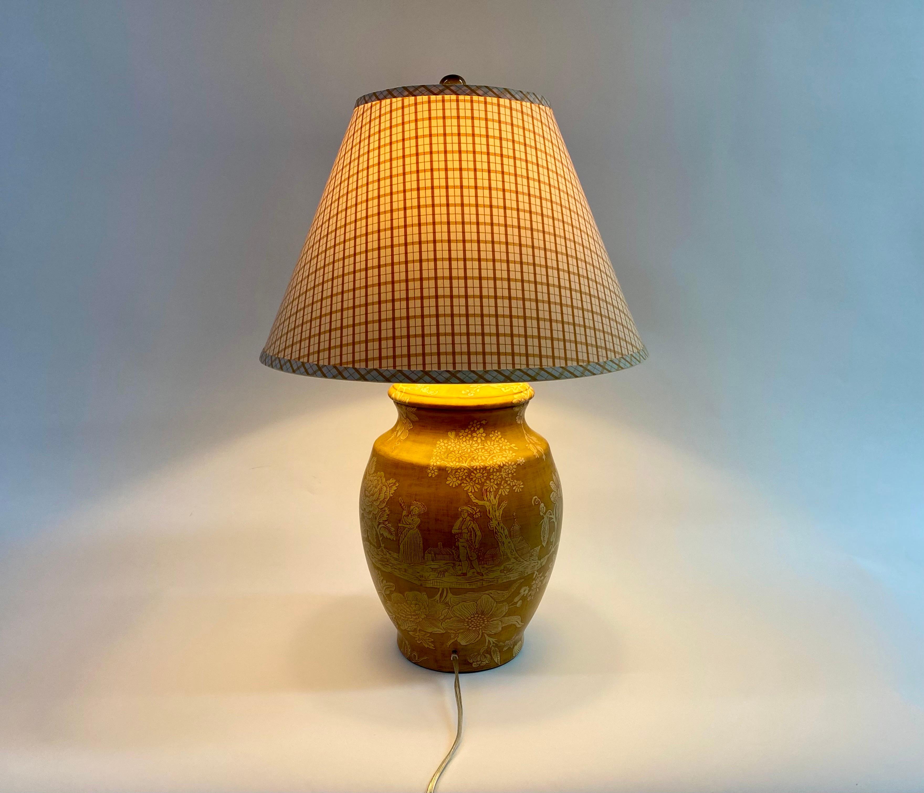 An exquisite midcentury ceramic lamp in French country or Provincial style by Pierre Deux. The urn converted lamp is made of ceramic in a fine yellow mustard one and features beautiful hand painted scenes of man and woman in the country with floral