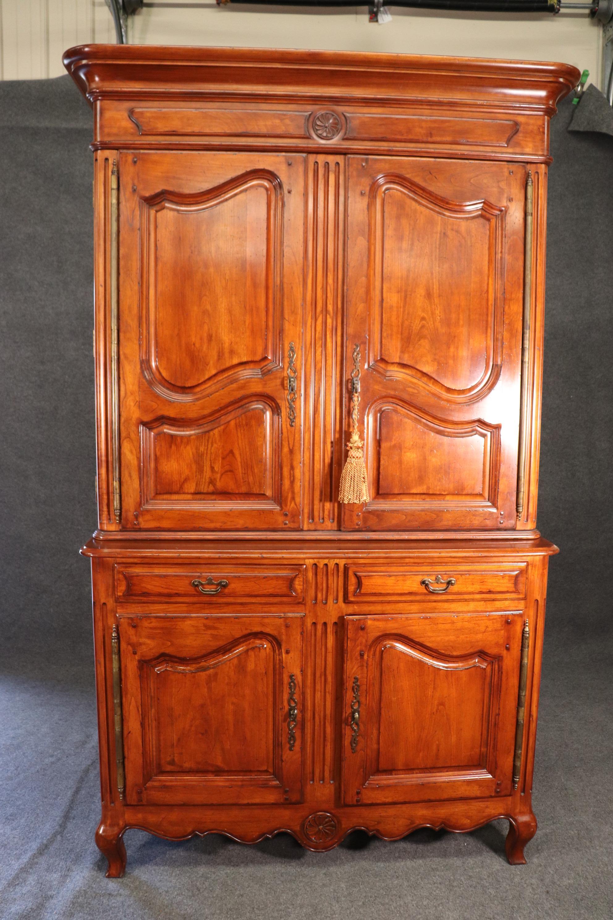 This is a gorgeous solid cherry country French copy of a 200 year old wardrobe or linen press. The piece is designed in the Pierre Deux traditon with pinned and pegged joinery and butterfly doors with enormous brass hinges. The cabinet is in 2