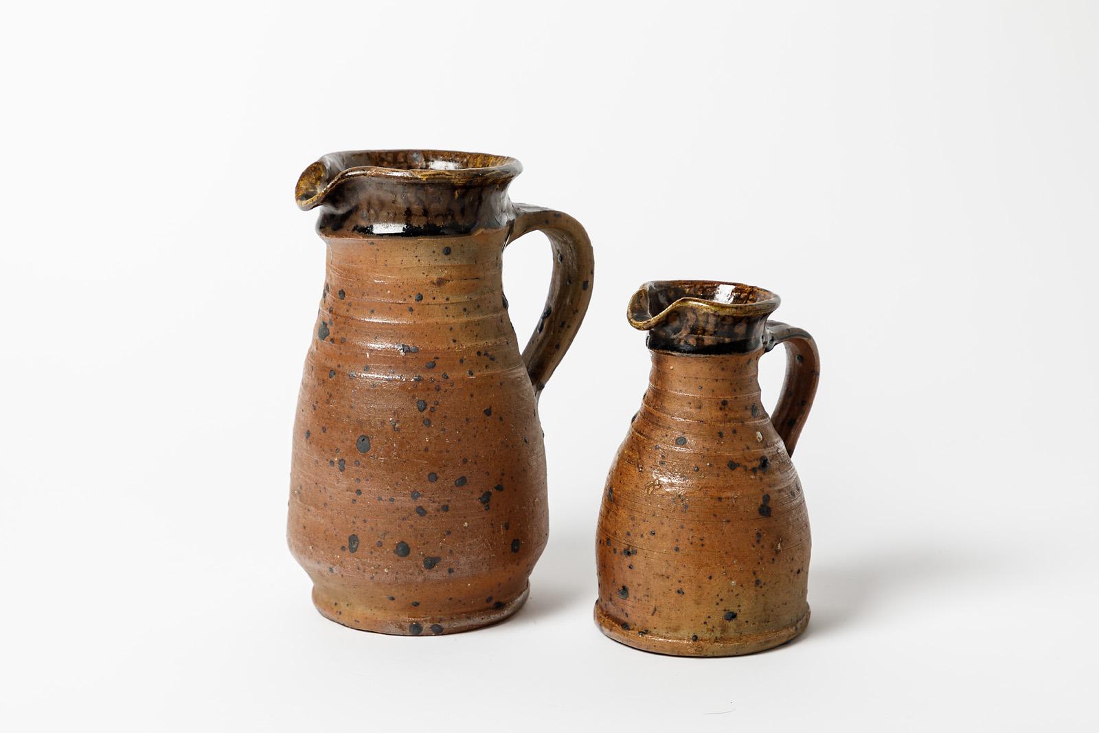 Pierre Digan.

Pair of stoneware ceramic pitchers. 

Original perfect condition.

Black and brown stoneware ceramic colors.

Realised in la Borne circa 1970.

Measures: Number one : height 21 cm Large 15 cm.
Number two height 16 cm Large