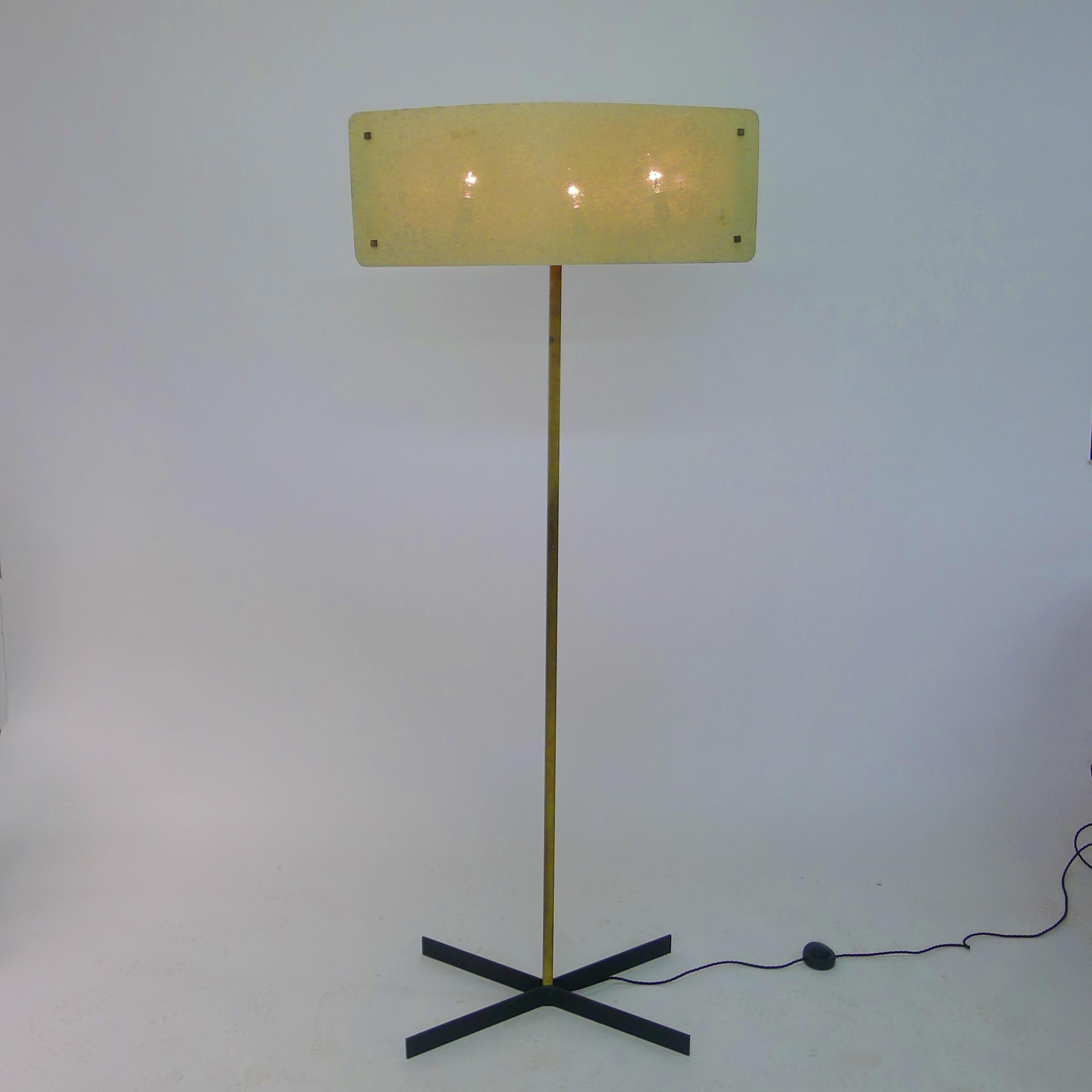 Pierre Disderot (francés 1920-1991)
Lámpara de pie, años 50
pantalla curva de metal perforado esmaltado blanco en dos partes, sujeta con tuercas cuadradas de latón, sobre una columna cuadrada de latón y pies metálicos cruzados

Las perforaciones de