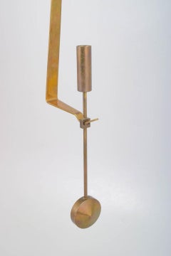 Pierre Forsell, Skultuna. Wall candle holder in brass with pendulum suspension