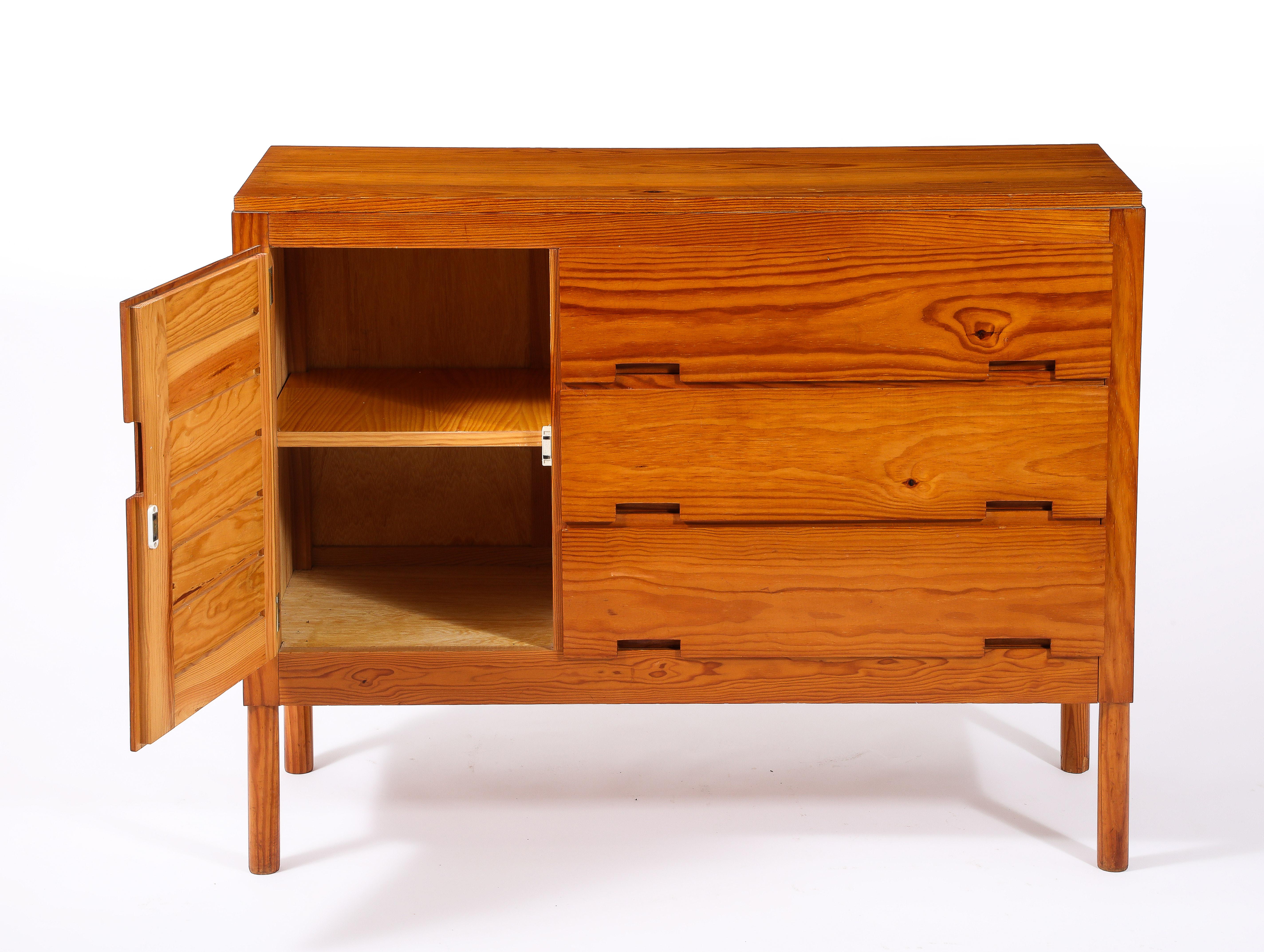 A pair of pine chests from the “weekend” series with three drawers and one door, slats construction, and cutout handles.
