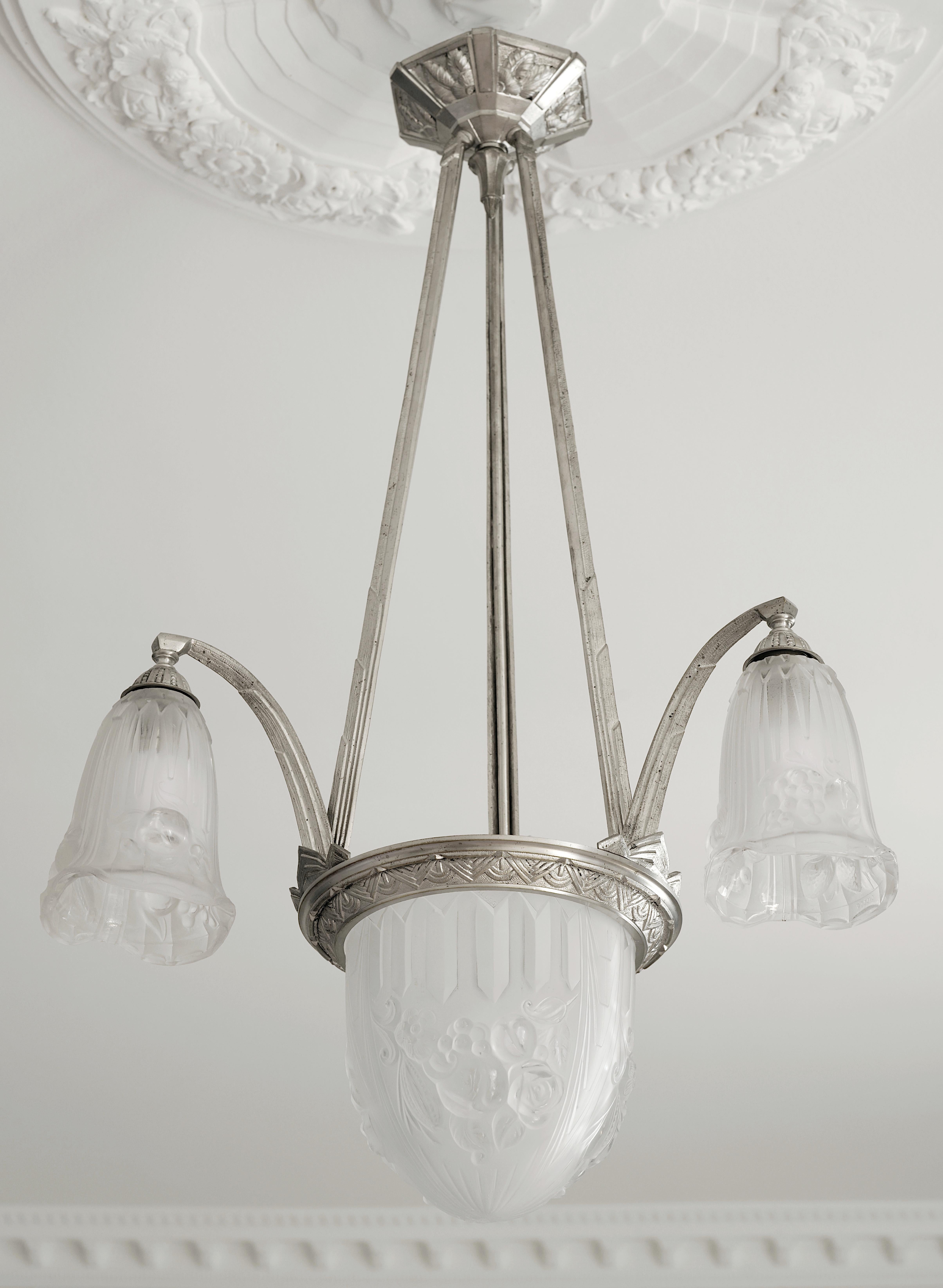Lampadario francese Art Déco di Pierre GILLES, 27 rue Esquirol, Parigi 13e, Francia, anni '20. I paralumi in vetro spesso e modellato sono appesi all'apparecchio originale in bronzo nichelato. Altezza: 30.3