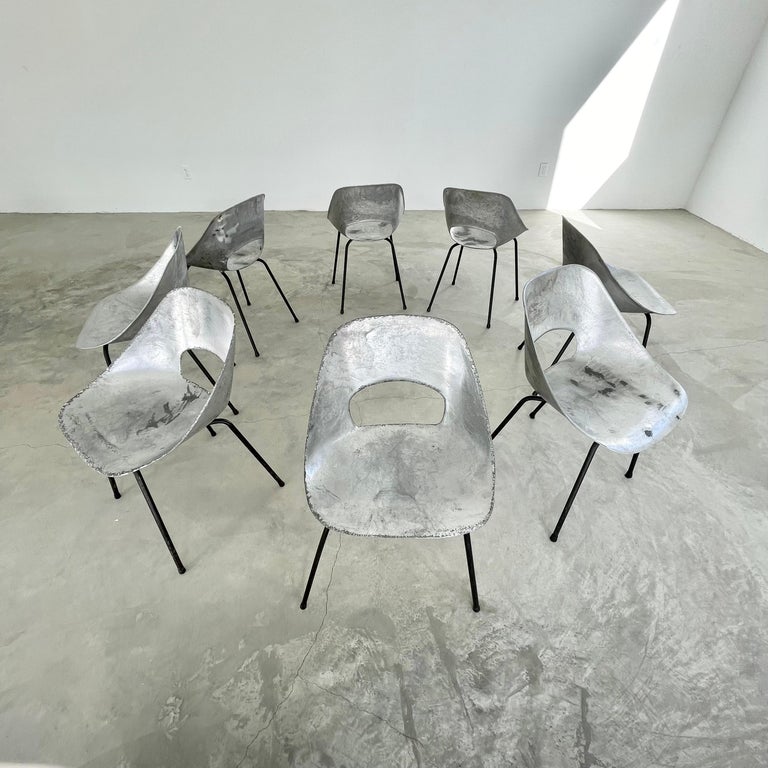 Gorgeous set of 8 aluminum chairs by Pierre Guariche. Cast aluminum frame sits on four iron legs. Great vintage condition and beautifully minimal design. Extremely rare especially in a set of 8. The non conventional beauty of these chairs makes them