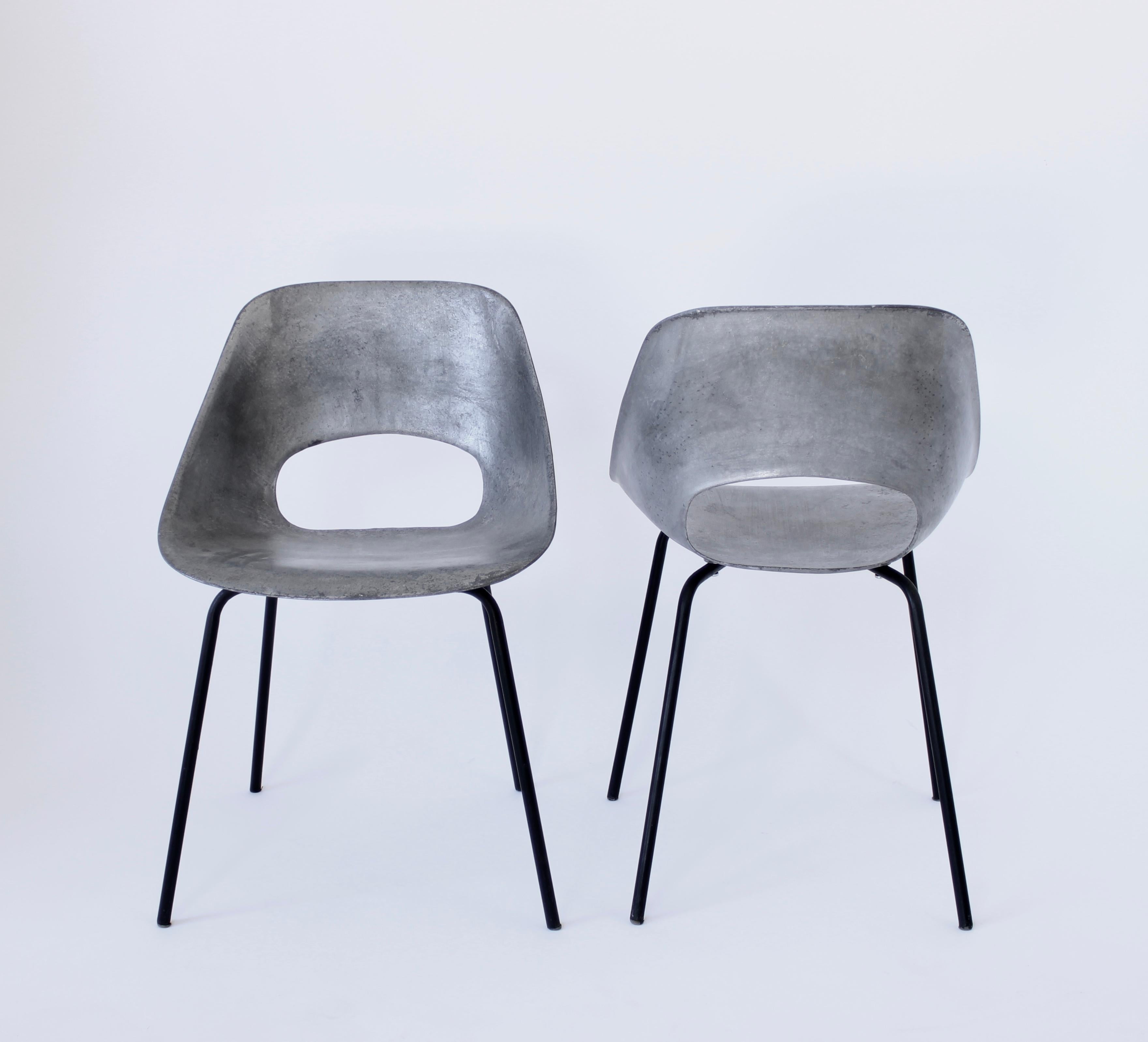 Pair of cast aluminum Tulip chairs by Pierre Guariche for Steiner, France, 1954.
Sculpted and curved cast aluminum seat with an opening on the seat on sleek four leg black tubular metal base. Statement chair and collectable. Comfortable and also a