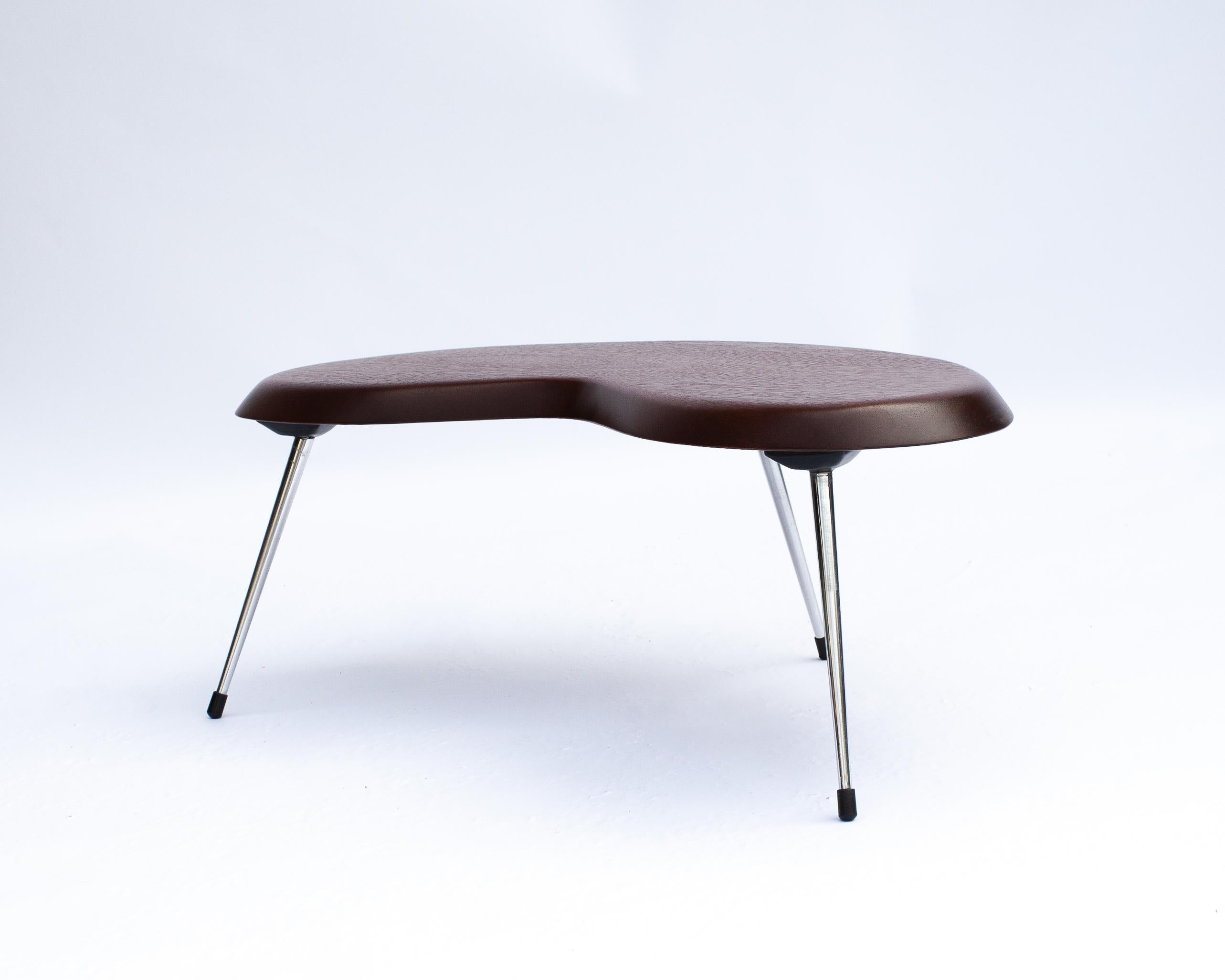 La table basse de Pierre Guariche, datant de 1953, est un exemple raffiné du modernisme français du milieu du siècle, illustrant sa maîtrise de la forme, de la fonction et du matériau. Avec ses lignes épurées et ses proportions précises, la table