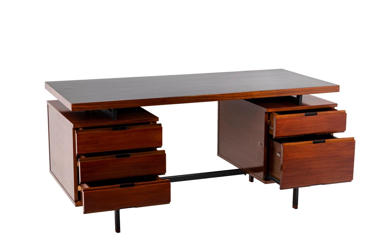 Pierre Guariche, attributed to.

Desk in mahogany composed of two compartments opening by five drawers connected by a stud in black lacquered metal standing on four straight legs linked by studs in black lacquered metal. Tray covered with black