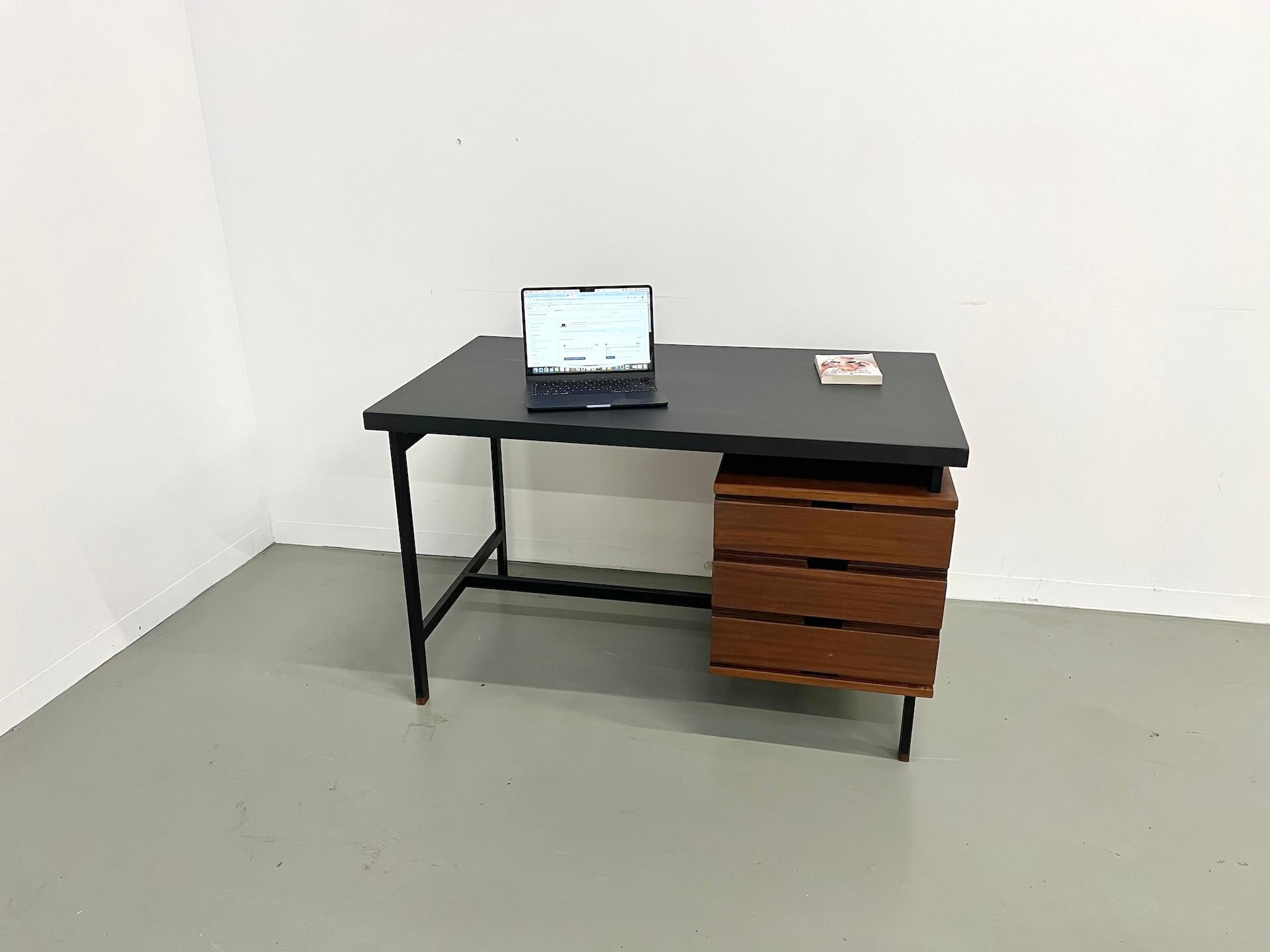 Laissez-vous séduire par ce bureau emblématique de Pierre Guariche, pièce maîtresse des années 60.

Avec son esthétique soignée et vintage, elle incarne le design français, associant un bois de teck chaleureux à un socle sculptural design en métal