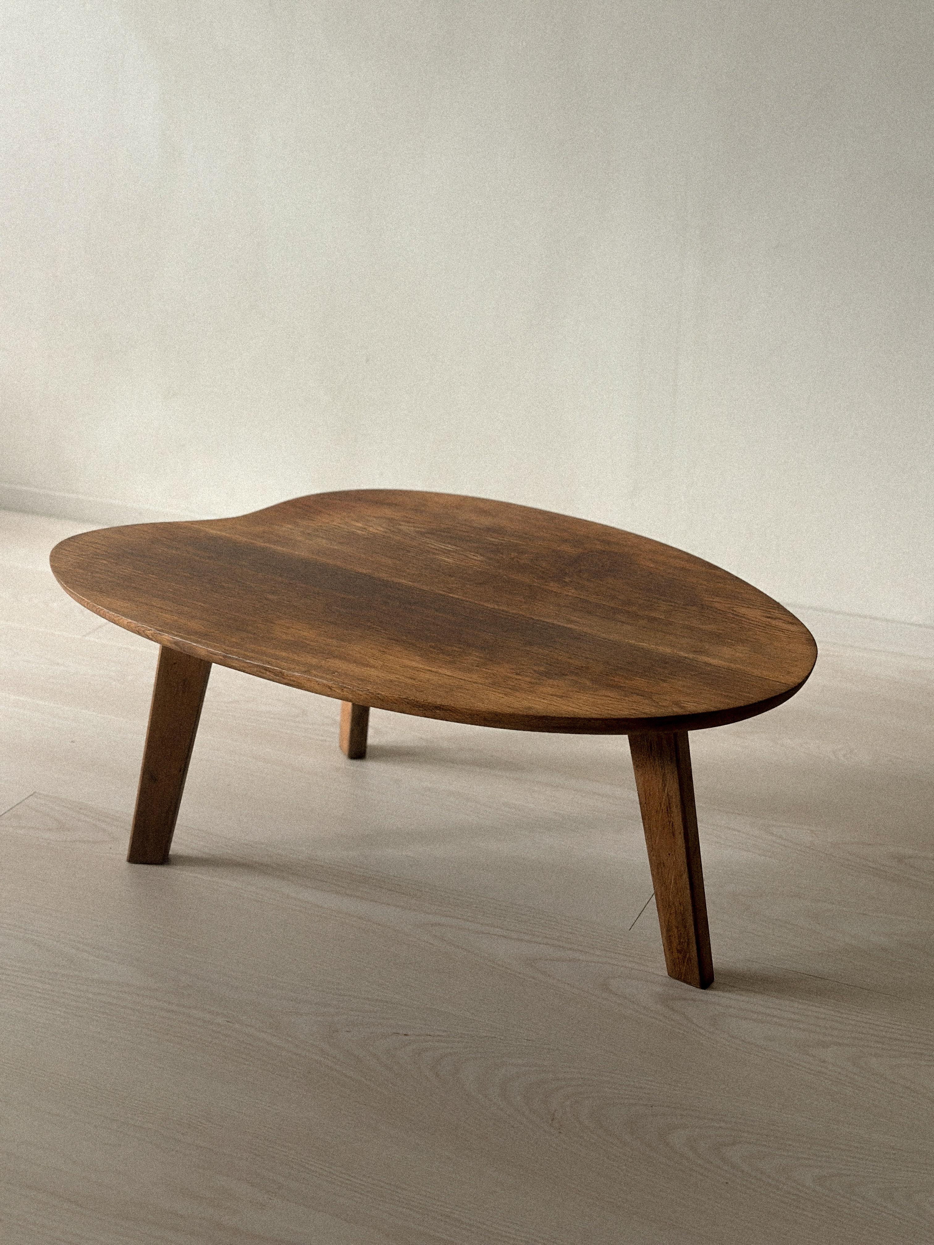 Mesa auxiliar diseñada por Pierre Guariche, producida por la Galería MAI de París, c. 1950. Fabricada íntegramente en roble, con líneas limpias y funcionales. Primera edición.
Presenta signos de antigüedad y uso, como arañazos superficiales, marcas