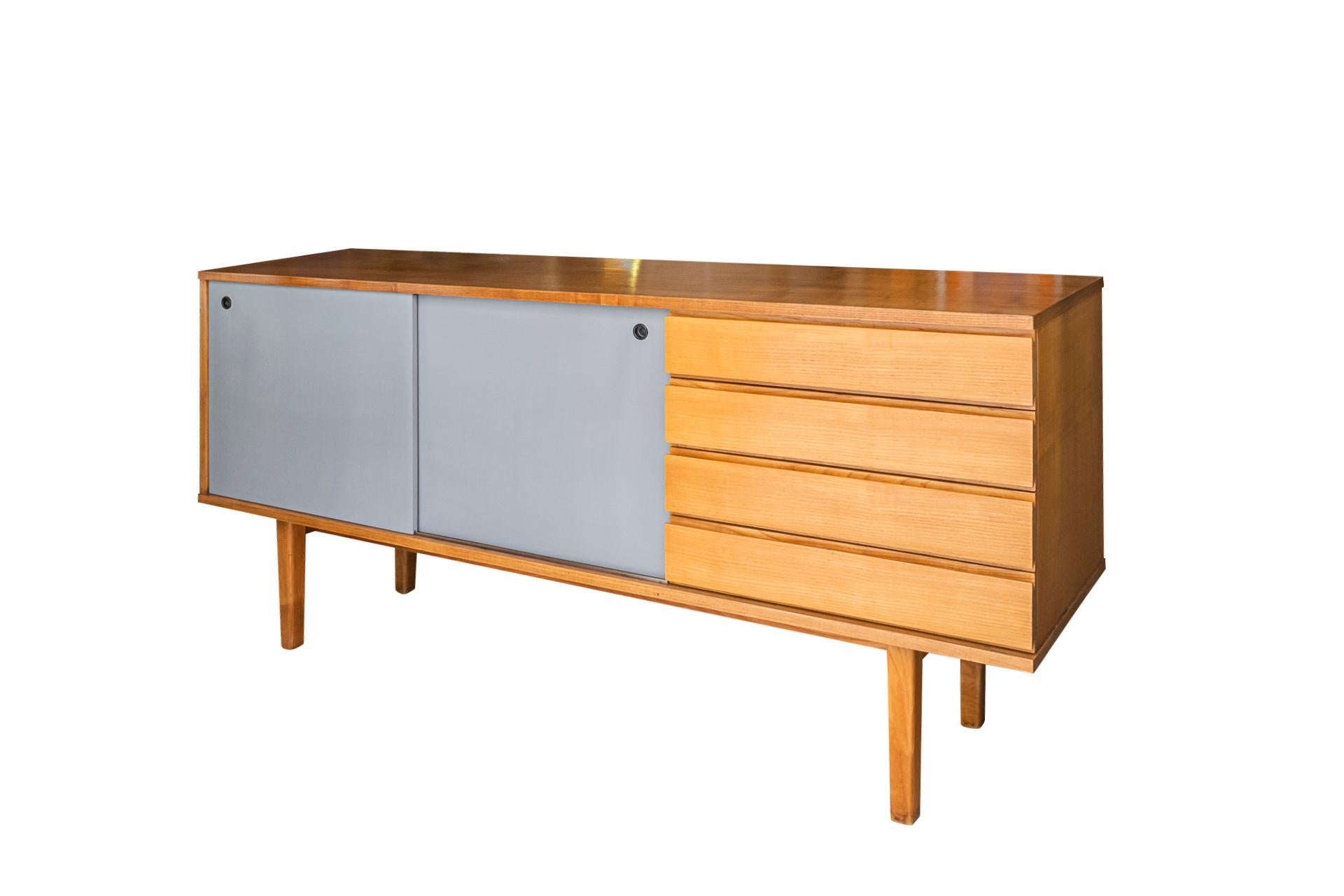 Pierre Guariche,
Sideboard,
Edition Minvielle,
Opening with 4 drawers and 2 lacquered sliding doors, 
Wood,
France, circa 1960.

Measures: 180 x 86 x 46 cm.

The architect Pierre Guariche was one of the leading modern furniture and lighting