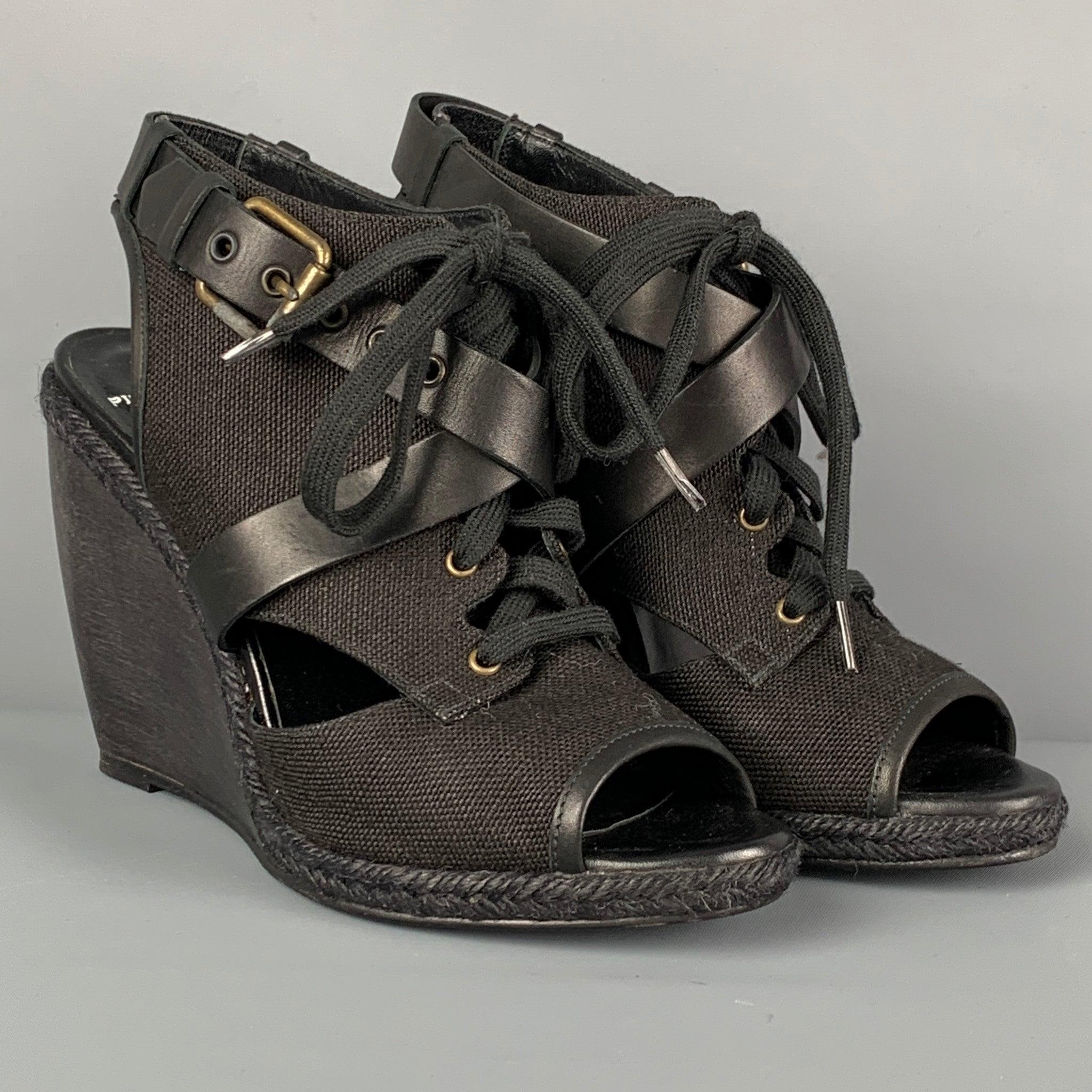 PIERRE HARDY sandals comes in a black canvas featuring a leather buckle strap detail, wedge heel, espadrille trim, and a lace up closure. Includes box. Made in Spainches 
Very Good
Pre-Owned Condition. 

Marked:   40 

Measurements: 
  Heel: 4