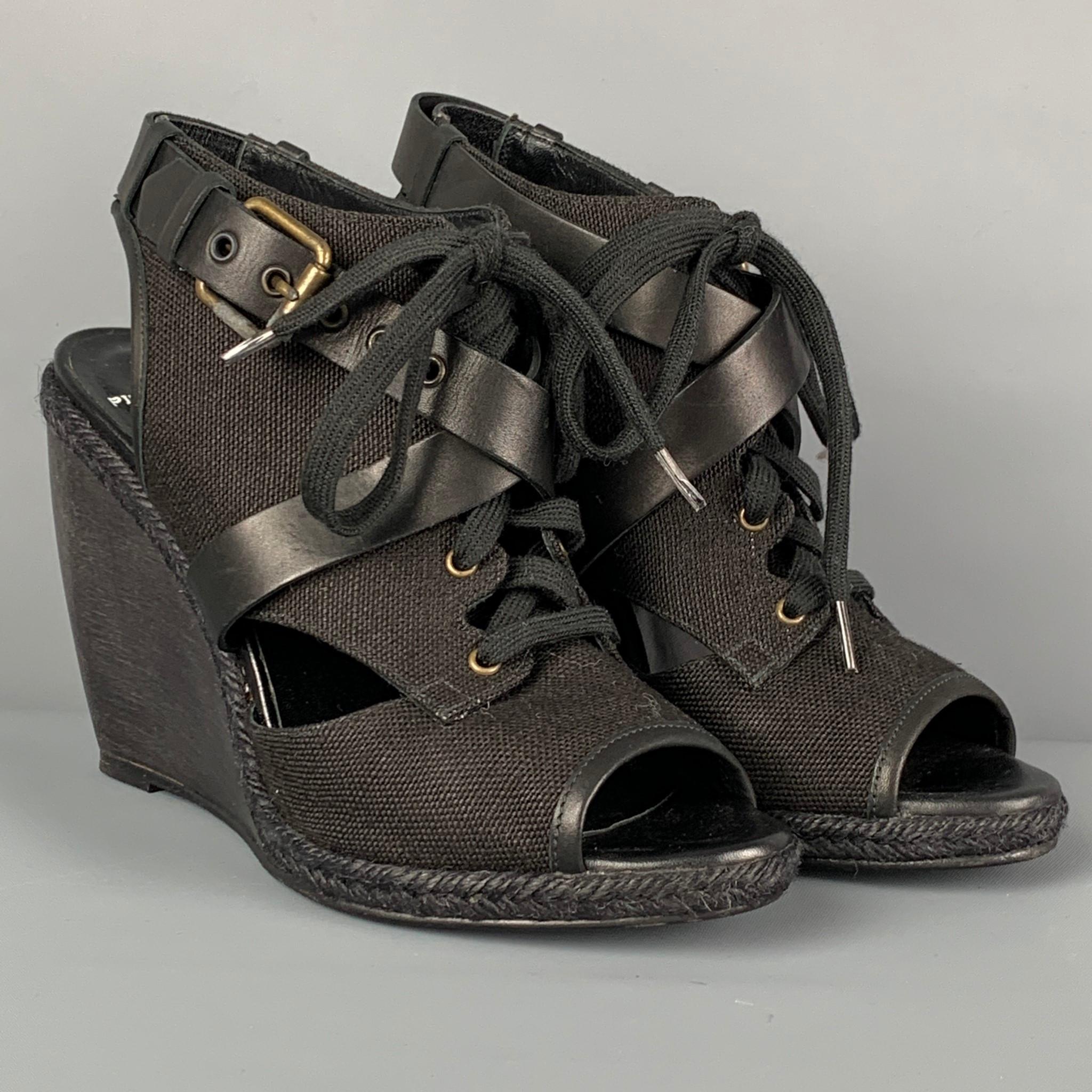 PIERRE HARDY sandals comes in a black canvas featuring a leather buckle strap detail, wedge heel, espadrille trim, and a lace up closure. Includes box. Made in Spain. 

Very Good Pre-Owned Condition.
Marked: 40
Original Retail Price: