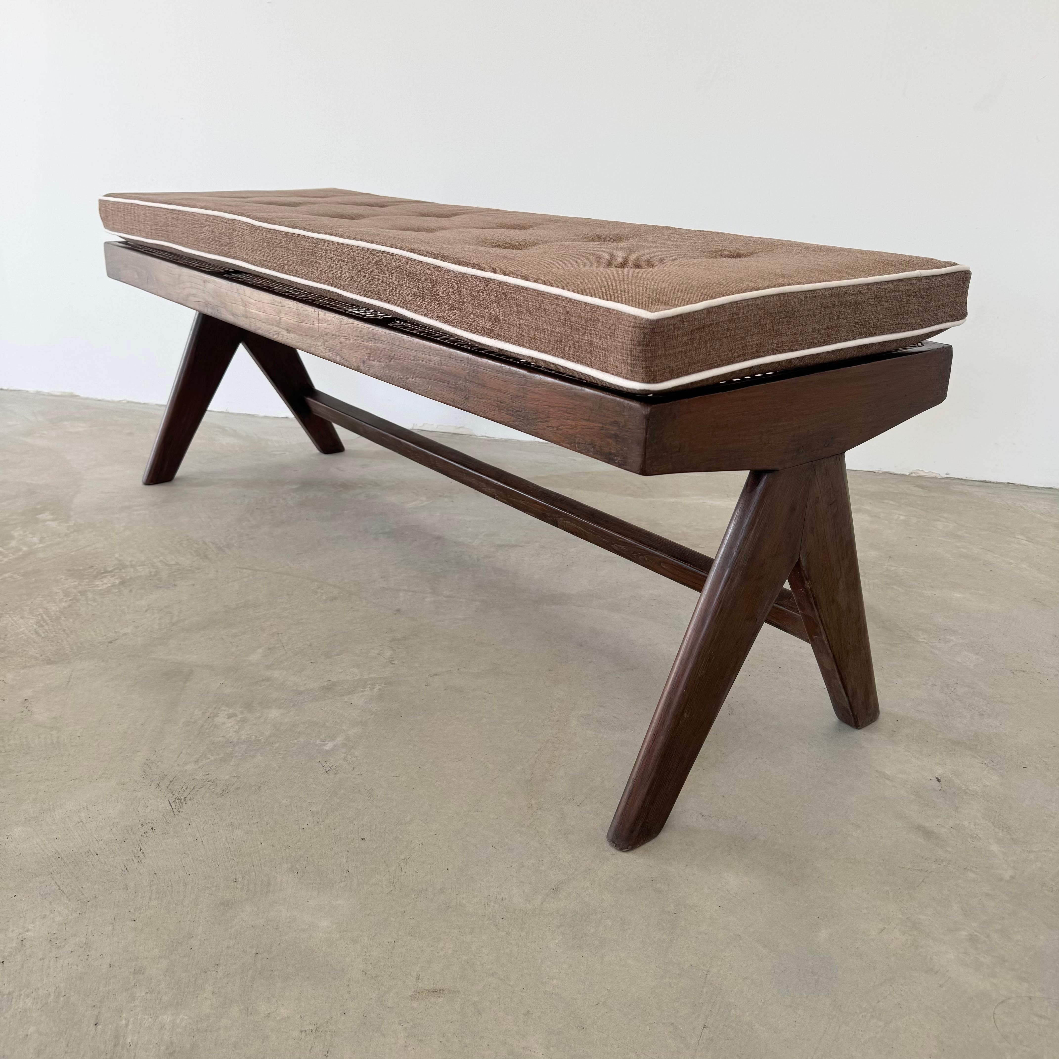 Beautiful teak bench titled the King Bench A Leg designed by Pierre Jeanneret for Chandigarh. Imported from India with care, this bench tells a story far beyond what the eye can see. With a rectangular seating section that spans across three cane