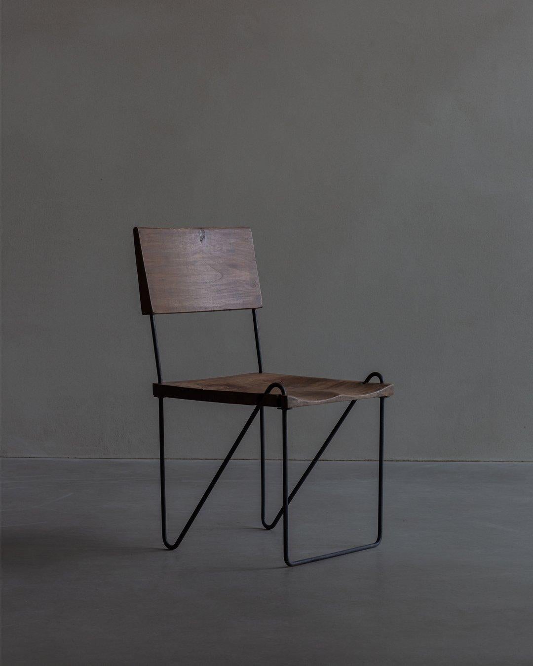 Chaise en teck et en fer, conçue par Pierre Jeanneret et datant de 1953-1954 environ. L'assise et le dossier sont en teck massif sculpté. Le dossier est légèrement incliné et sculpté de motifs complexes. Le siège est également sculpté dans du teck