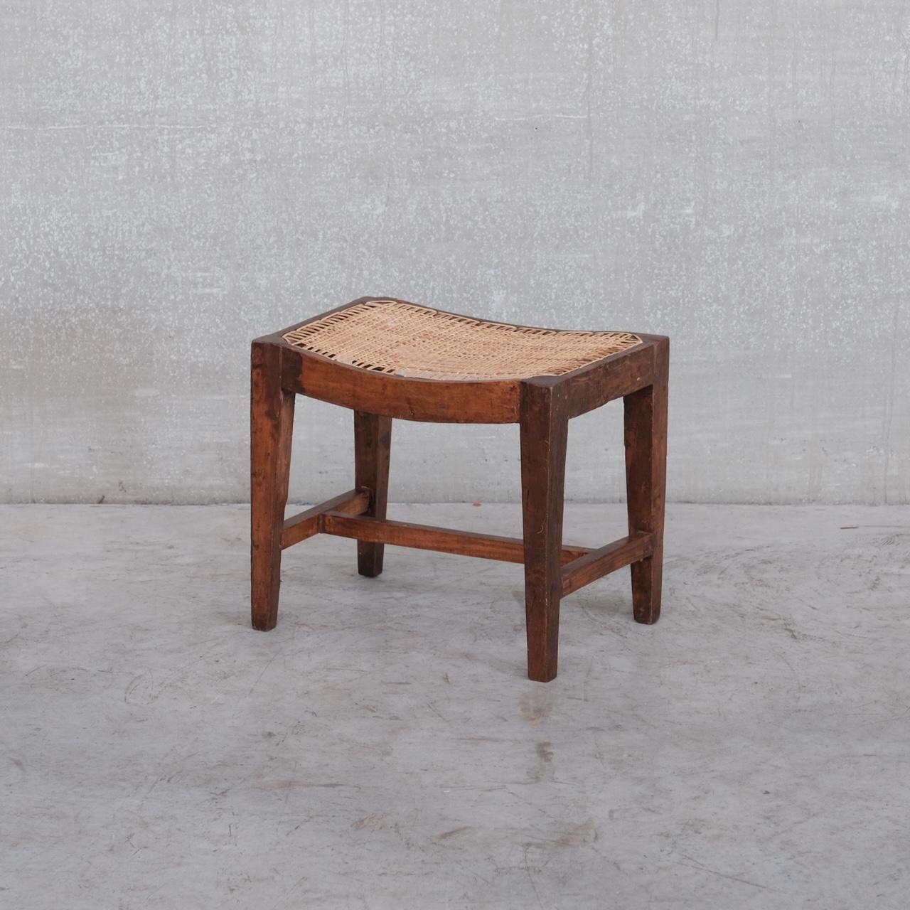 An original Pierre Jeanneret wooden stool.

India, Chandigargh, c1960s. 

Solid teak. 

PJ-SI-24-A Model. 

Caned top with bowed seat for comfort. 

A old metal label remains to one side which can be removed upon request. 

Some wear