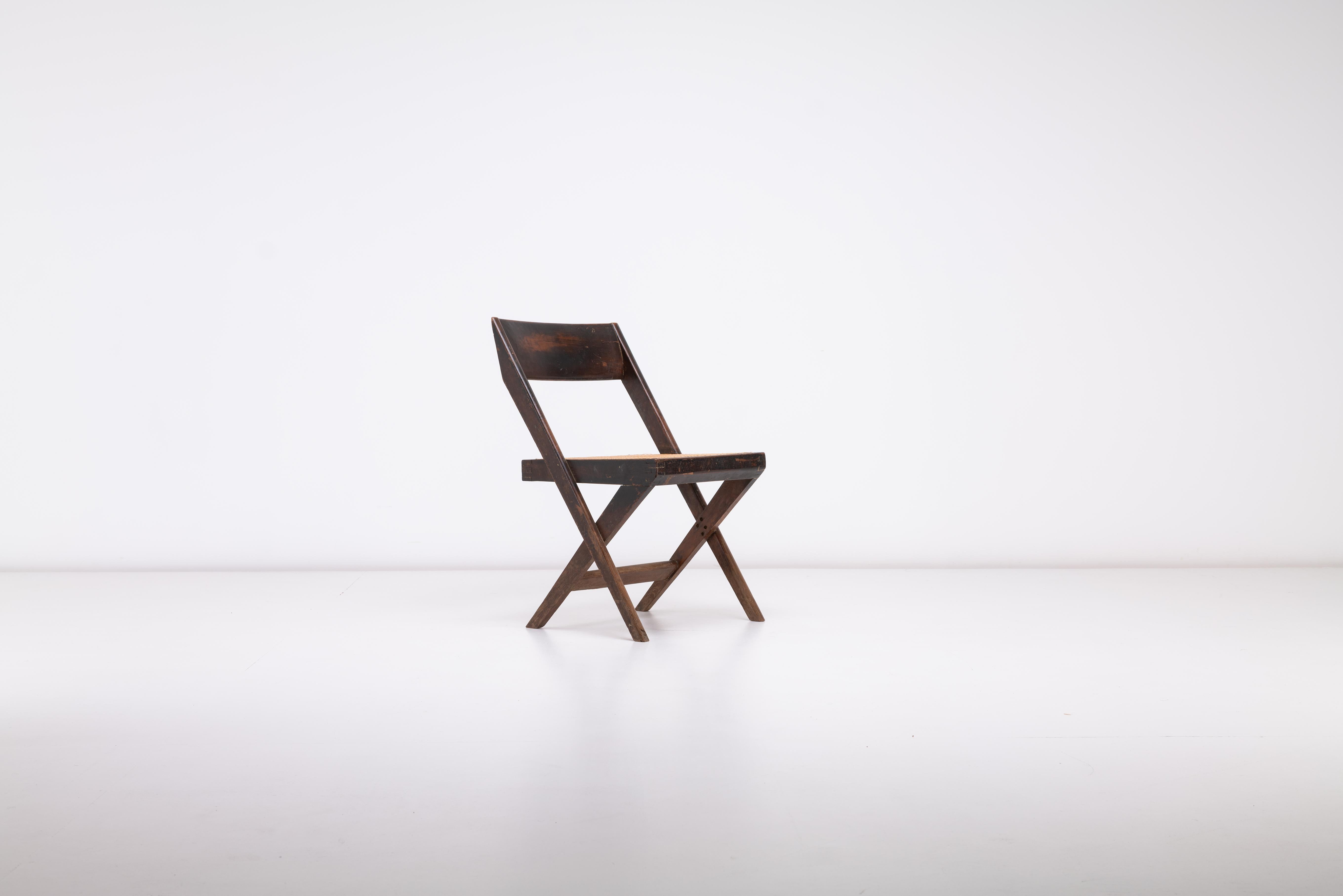 Cette chaise de bibliothèque Pierre Jeanneret & Eulie Chowdhury, fabriquée en teck avec une assise en rotin tressé à la main, est un parfait exemple du design moderne du milieu du siècle et d'un savoir-faire exceptionnel. Conçue pour la ville