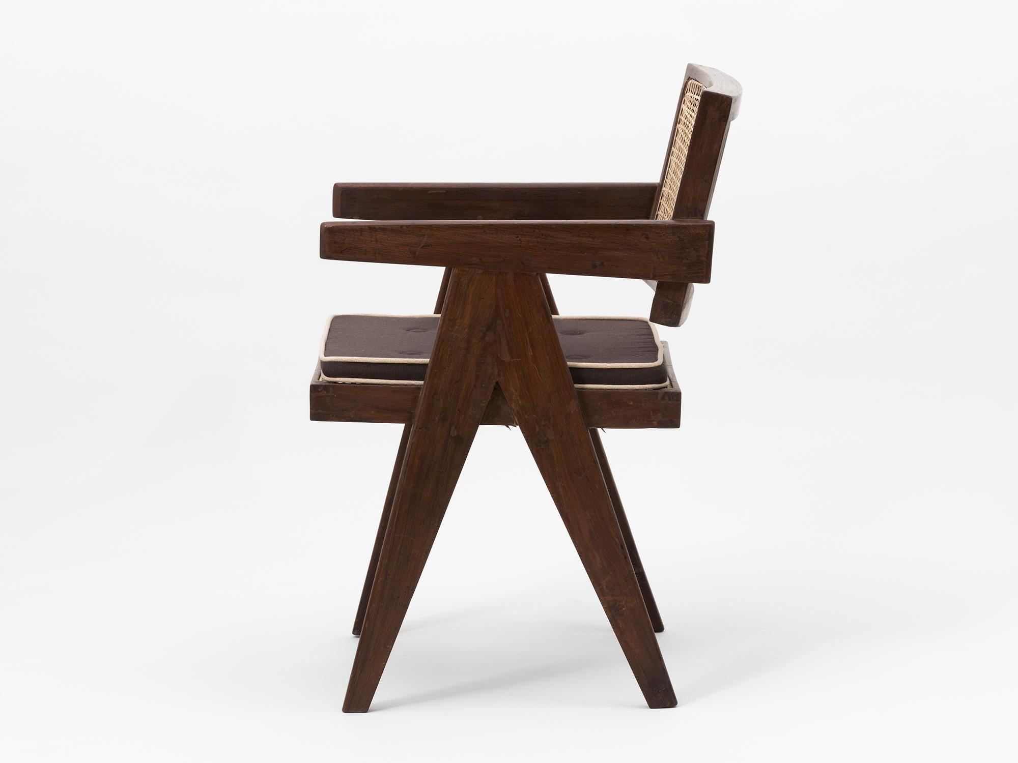 Original teak and wicker floating back armchair with cushion, designed by Pierre Jeanneret for the famous modernist capital city of Chandigarh, India that was designed by Le Corbusier, Jeanneret and their team. 

Referenced in 