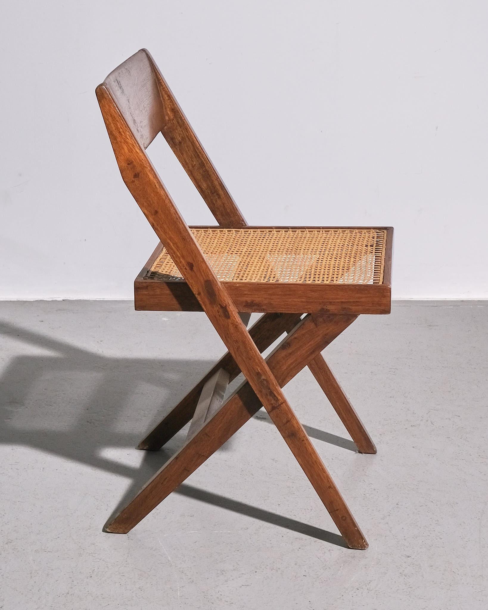 Dieser klassische Entwurf von Pierre Jeanneret wurde in den 1960er Jahren als Teil des berühmten Chandigarh-Projekts in Indien entwickelt. Das Gestell aus massivem Teakholz und die Sitzfläche aus geflochtenem Schilfrohr sind Ausdruck der für