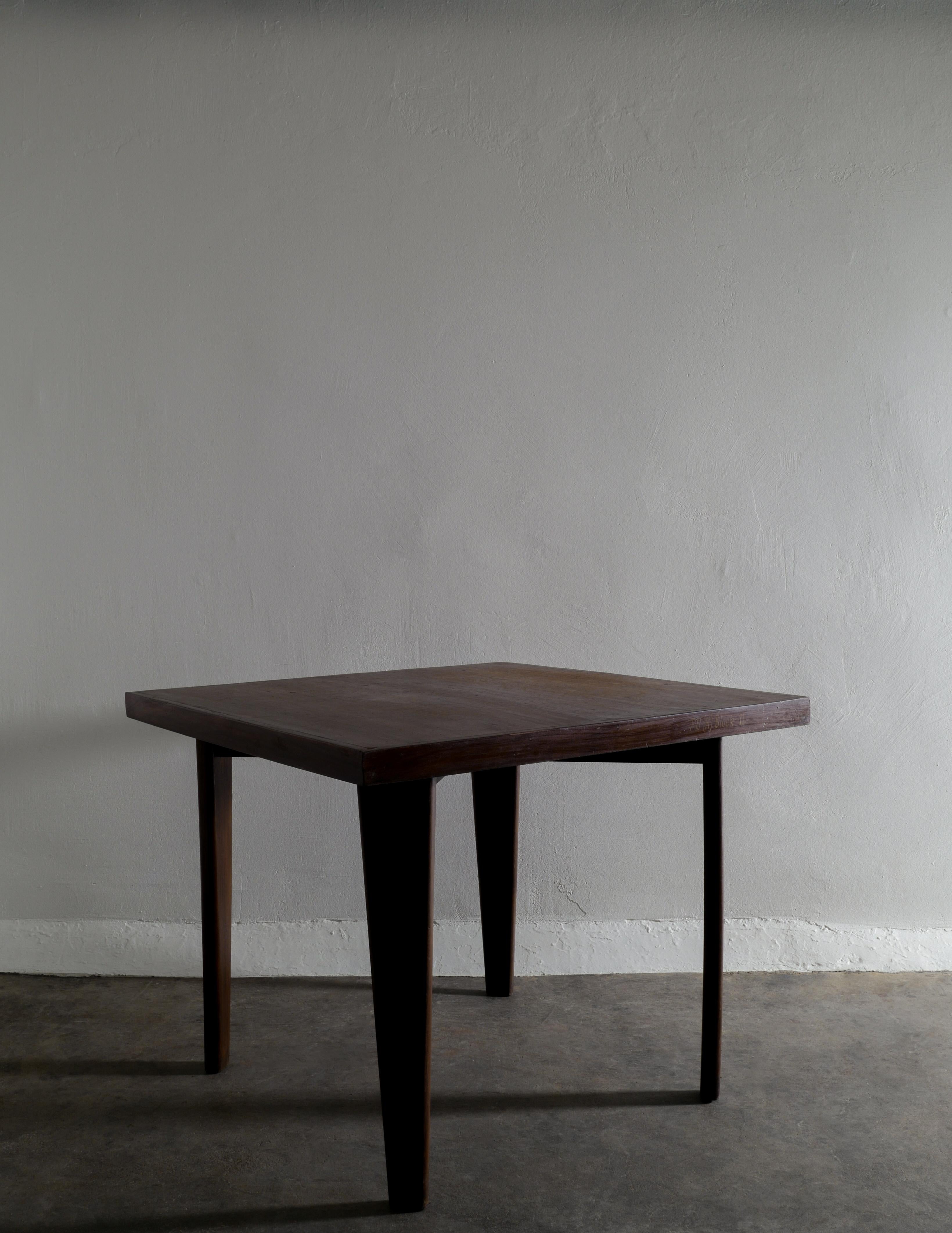 Very rare café / smaller dining table in a square style designed by Pierre Jeanneret in solid dark brown stained teak for Chandigarh, India in the 1950s. In good vintage condition with beautiful and honest patina from age and use. One of the sides